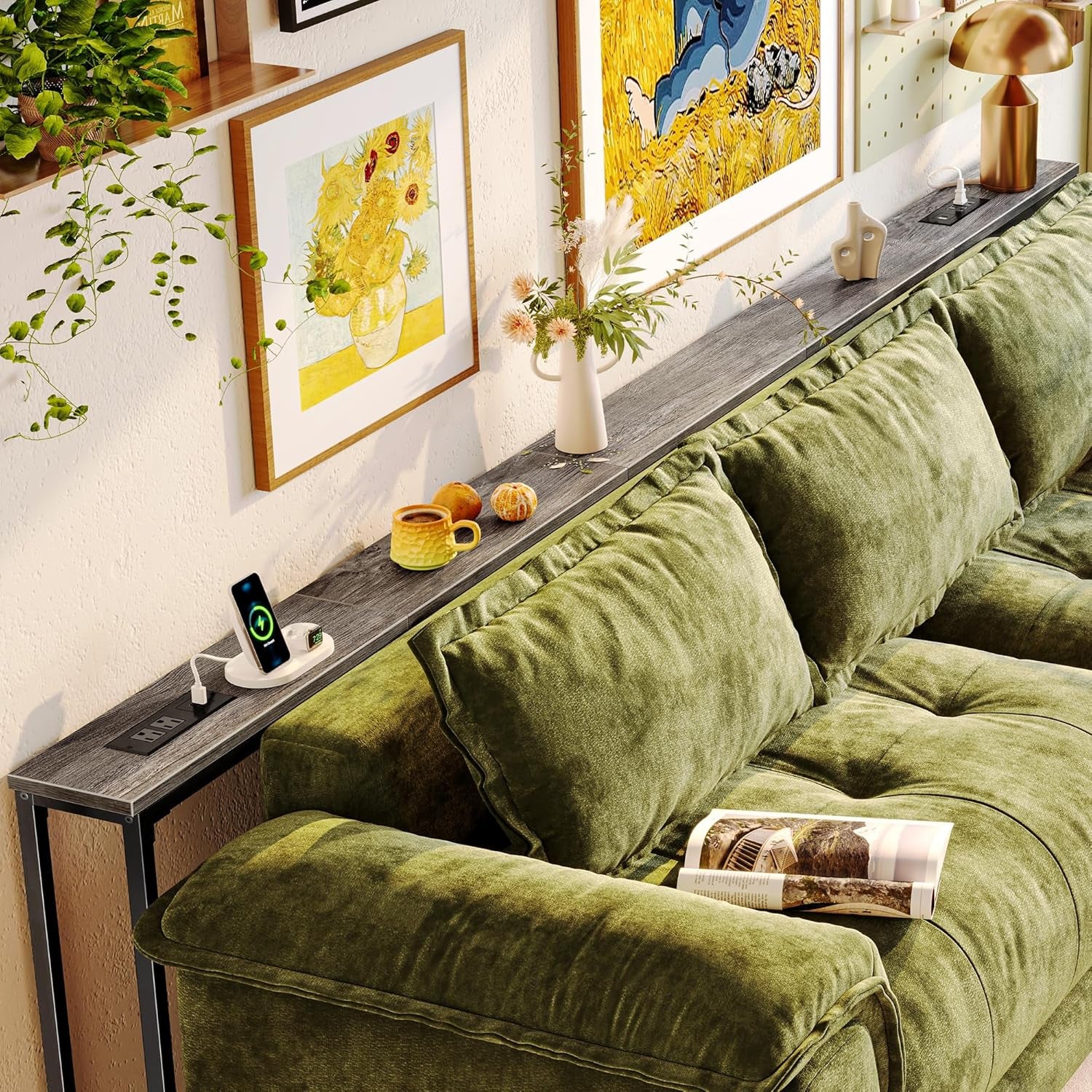 Long skinny gray wood console table behind a green sectional with charging module and decor.