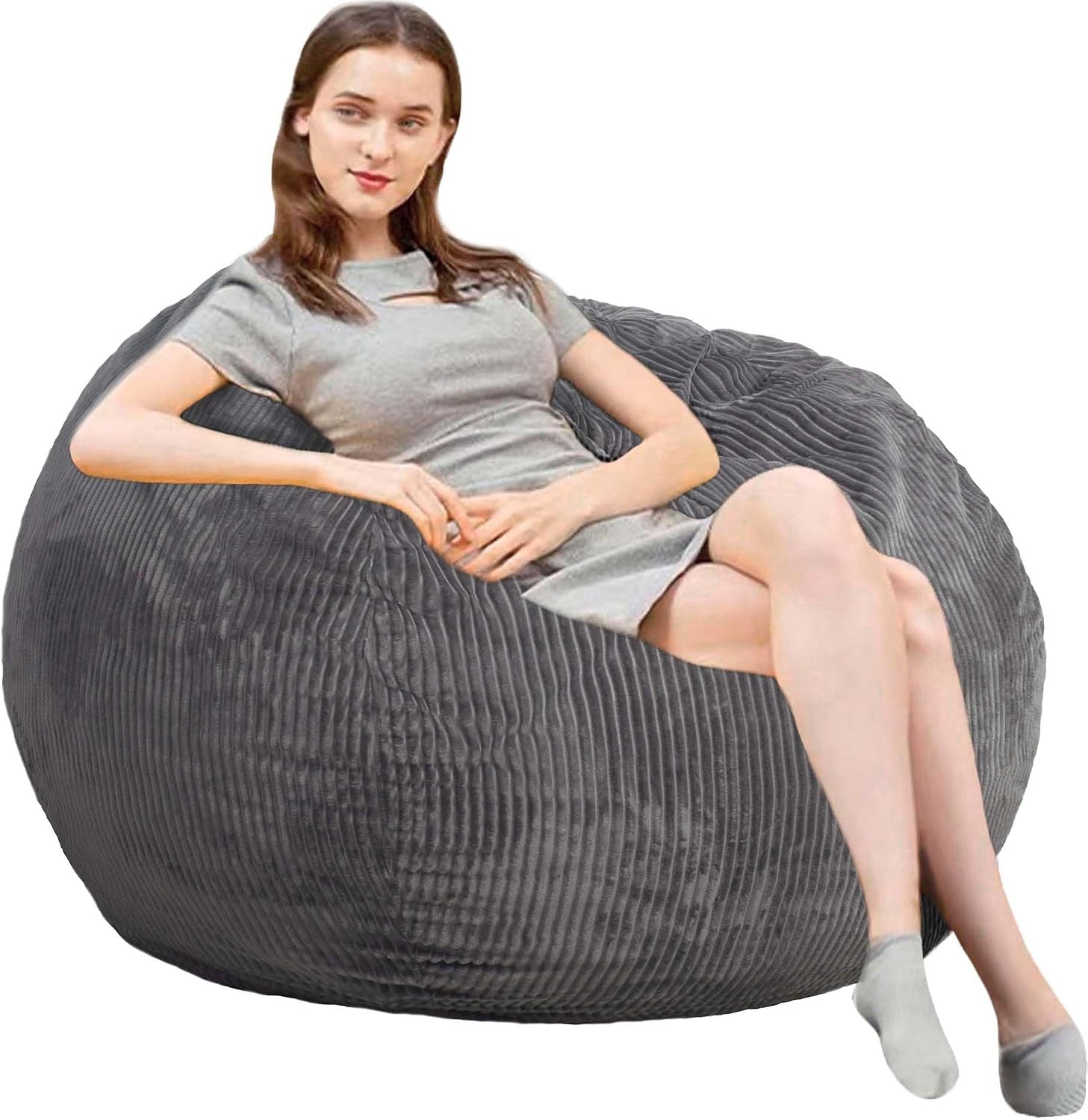 Woman reclining sideways on a large ribbed gray round bean bag against a white background.