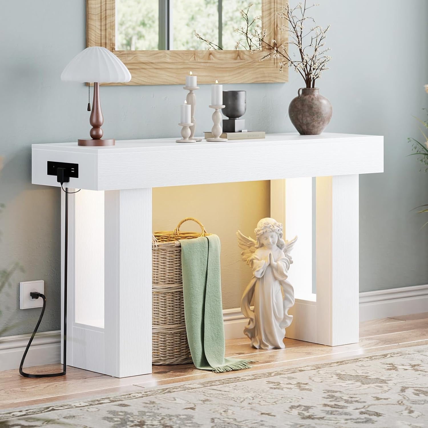 Front view of the table in white finish highlighting the lit interior, woven basket and angel statue beside it