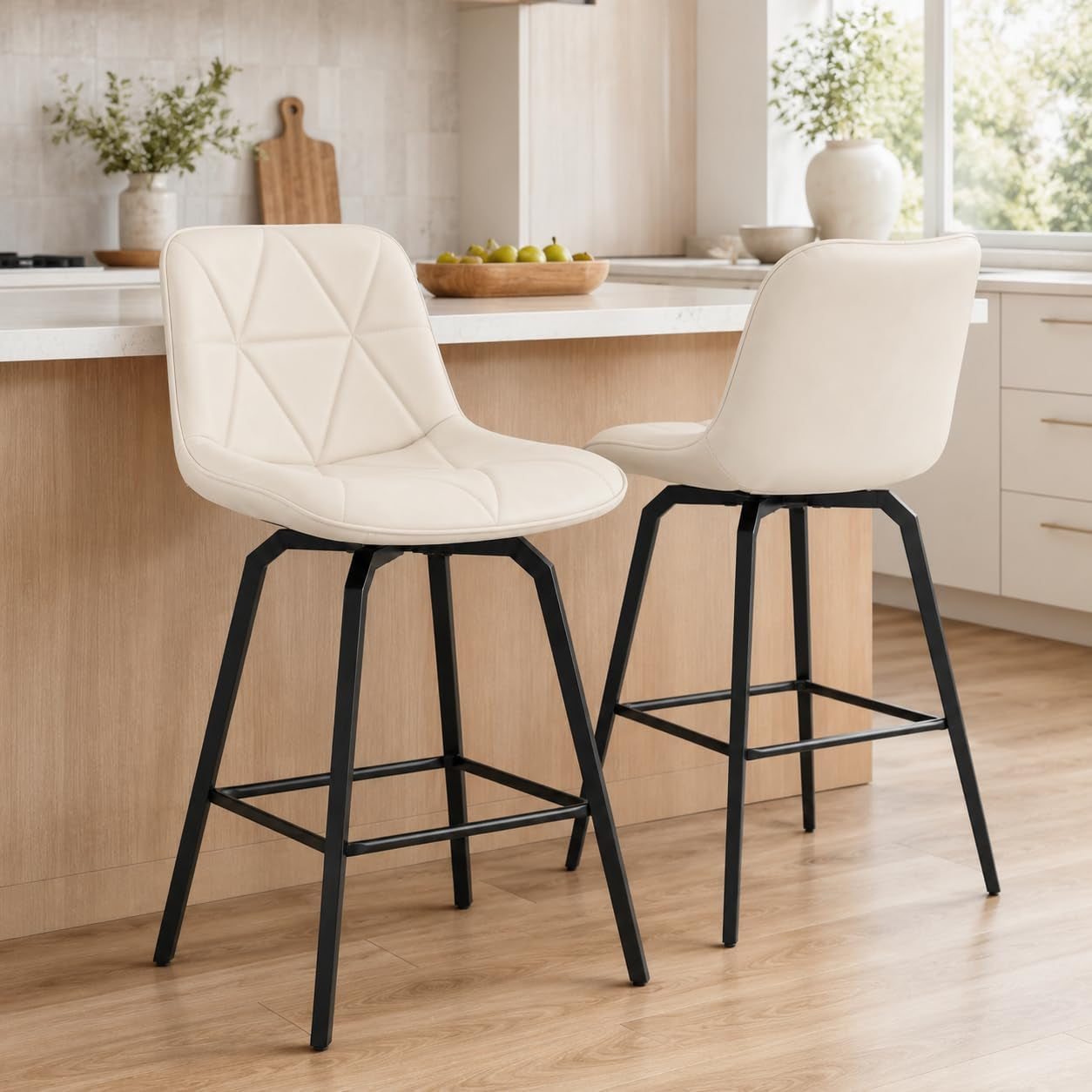 Two white faux-leather counter stools with black metal legs placed at a light wood kitchen island.