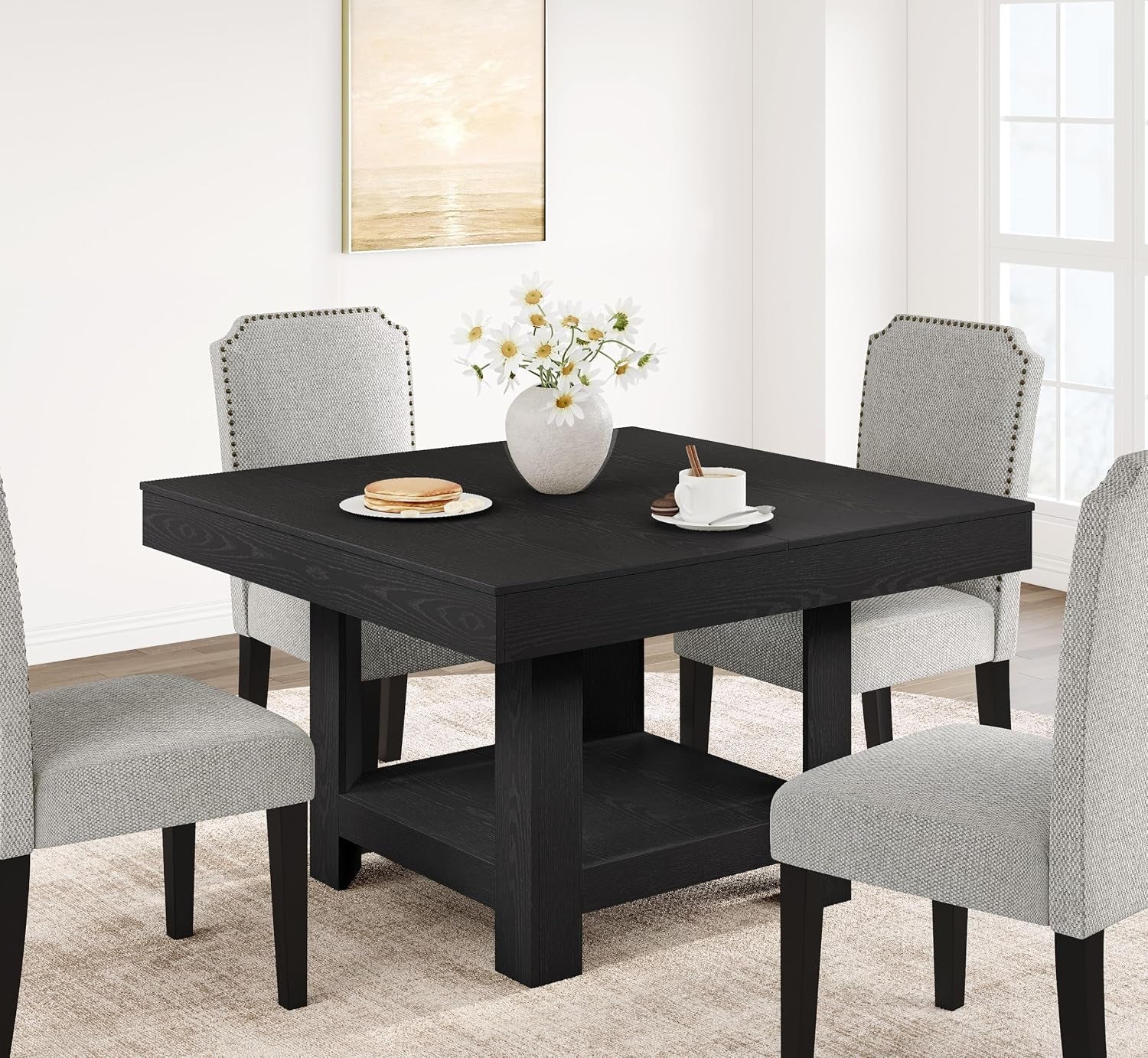 Square dining table in black finish shown with four upholstered chairs and a floral centerpiece.