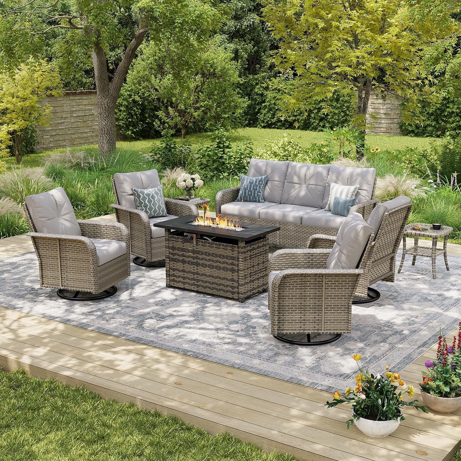 Beige wicker patio set arranged around a rectangular lit fire pit table on a patterned rug.