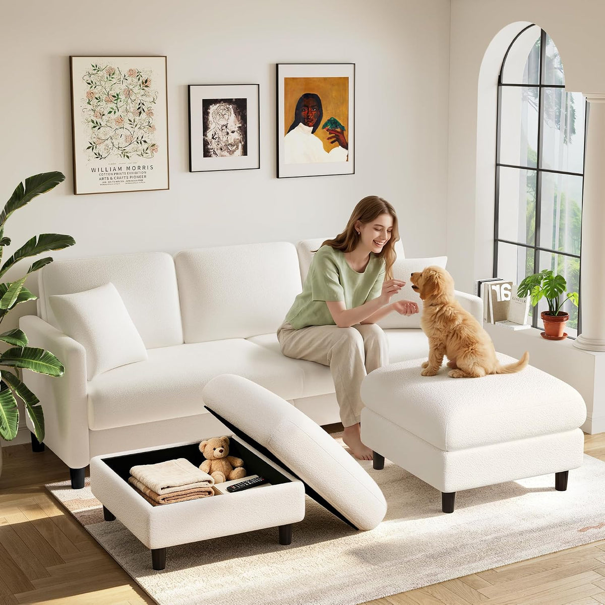 Bright living room with a beige loveseat, open storage ottoman, woman playing with a small dog