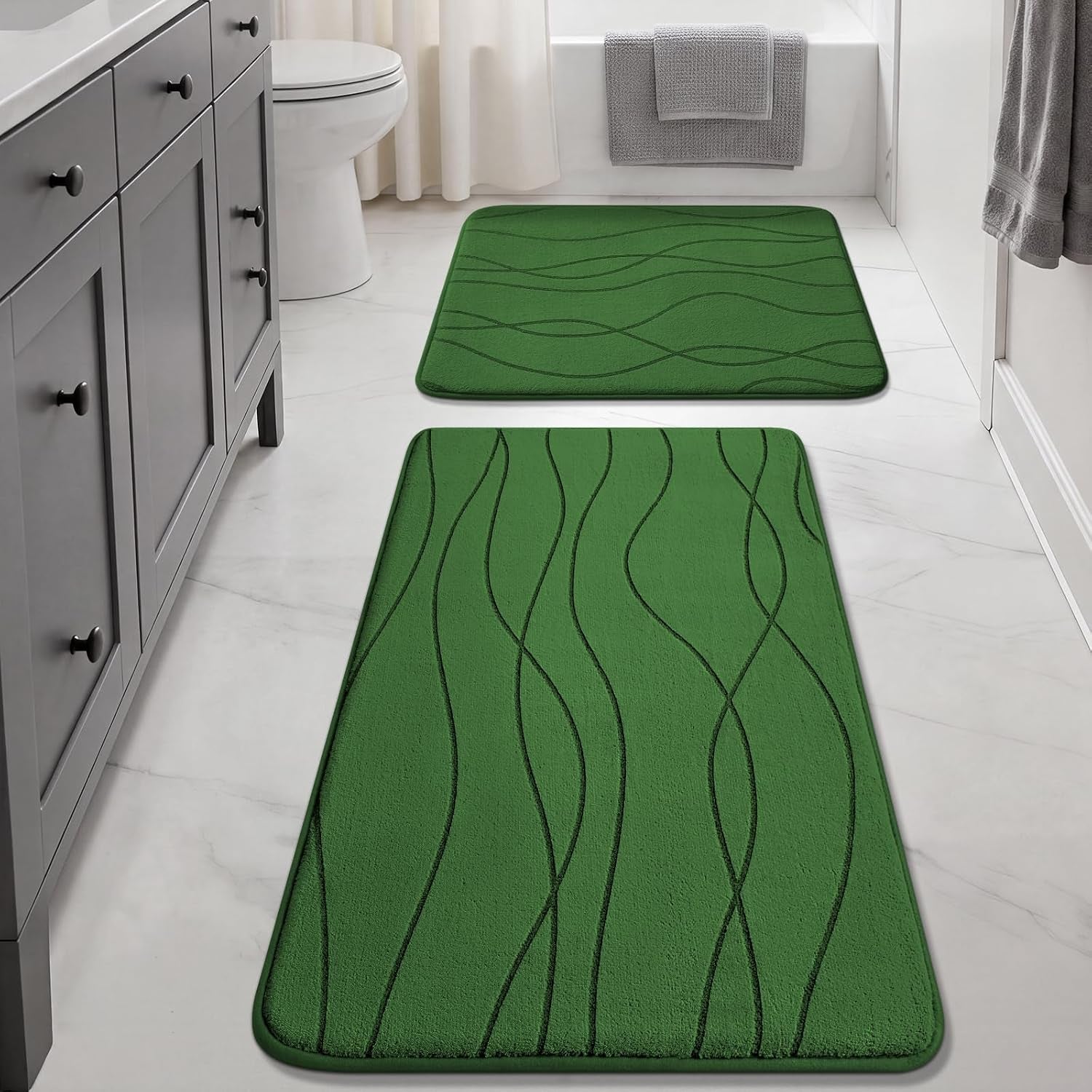 Green runner and square mat in a bright bathroom lined up toward the tub, wavy stitched design