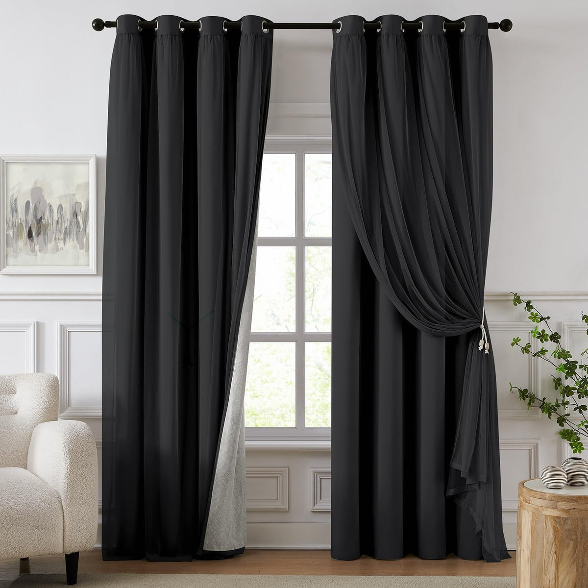 Window with deep black blackout curtains and a matching sheer pulled to the side in a neutral room.