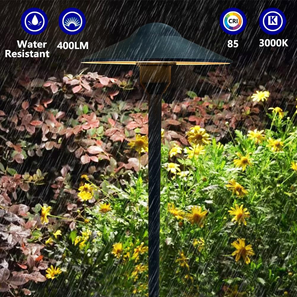 Close-up of a black pathway light shining over plants while heavy rain falls with water-resistance icons