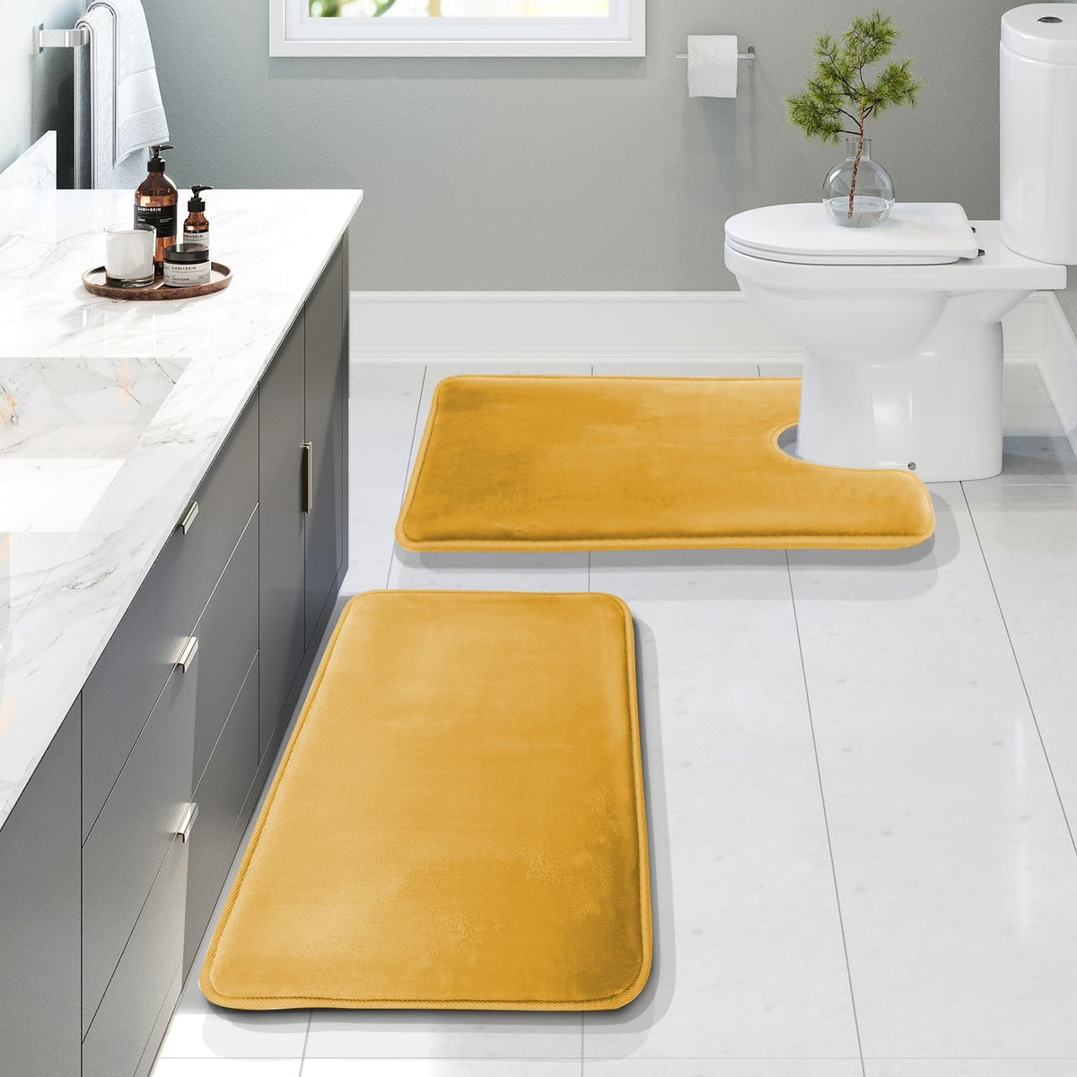 Bathroom scene with a mustard-yellow rectangular and U-shaped contour mat placed near a toilet.