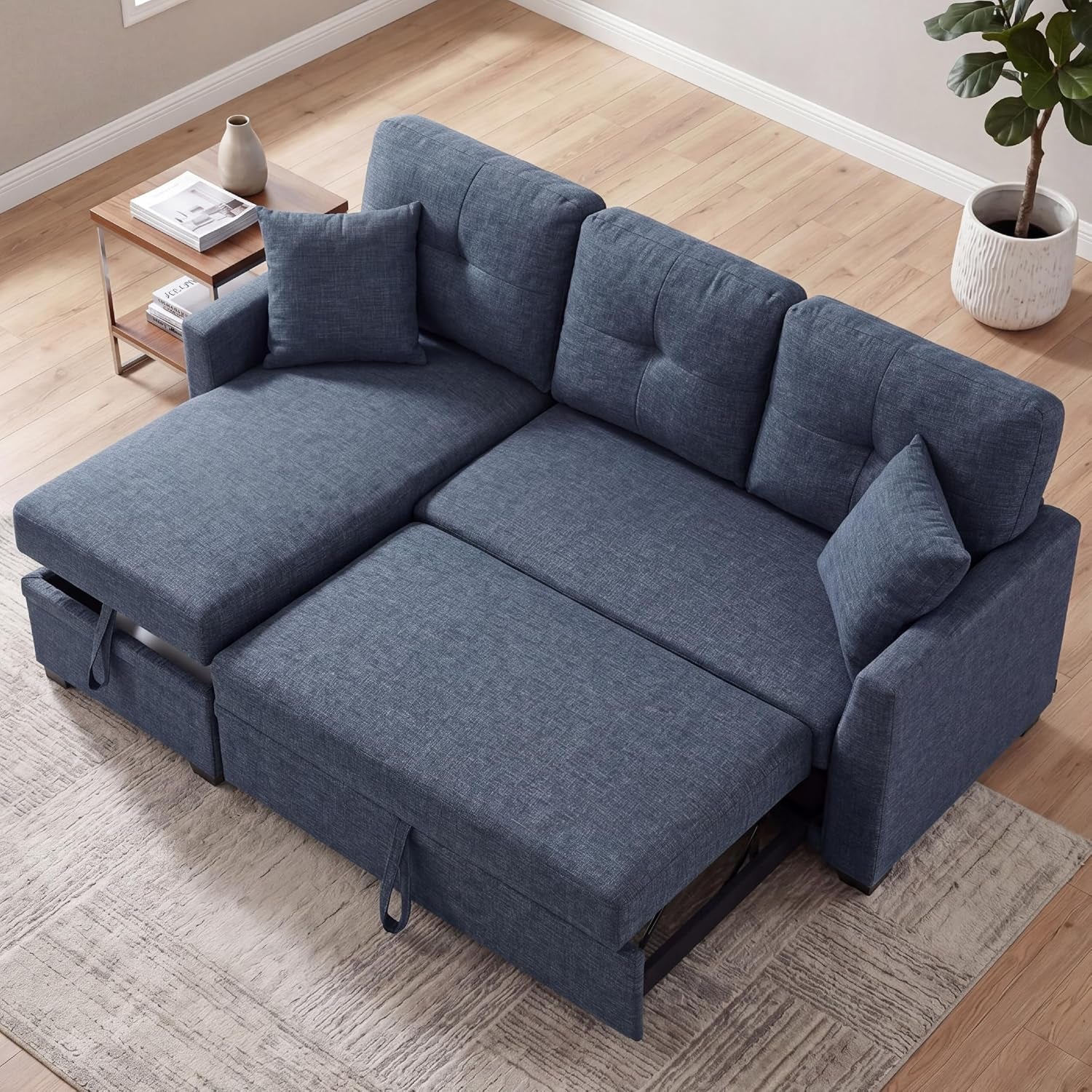 Top-down view of a blue tufted loveseat converted into a sleeper with chaise extended.