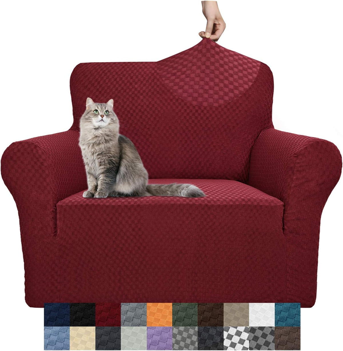 Burgundy stretch sofa cover on an armchair with a gray cat seated and a hand pulling the fabric at the top back.