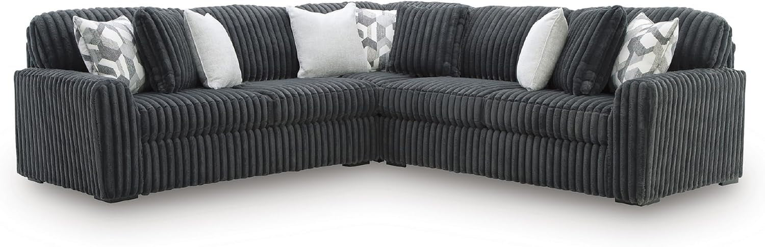 Corner view of a dark charcoal ribbed sectional on a white background, showing low black legs and patterned pillows.