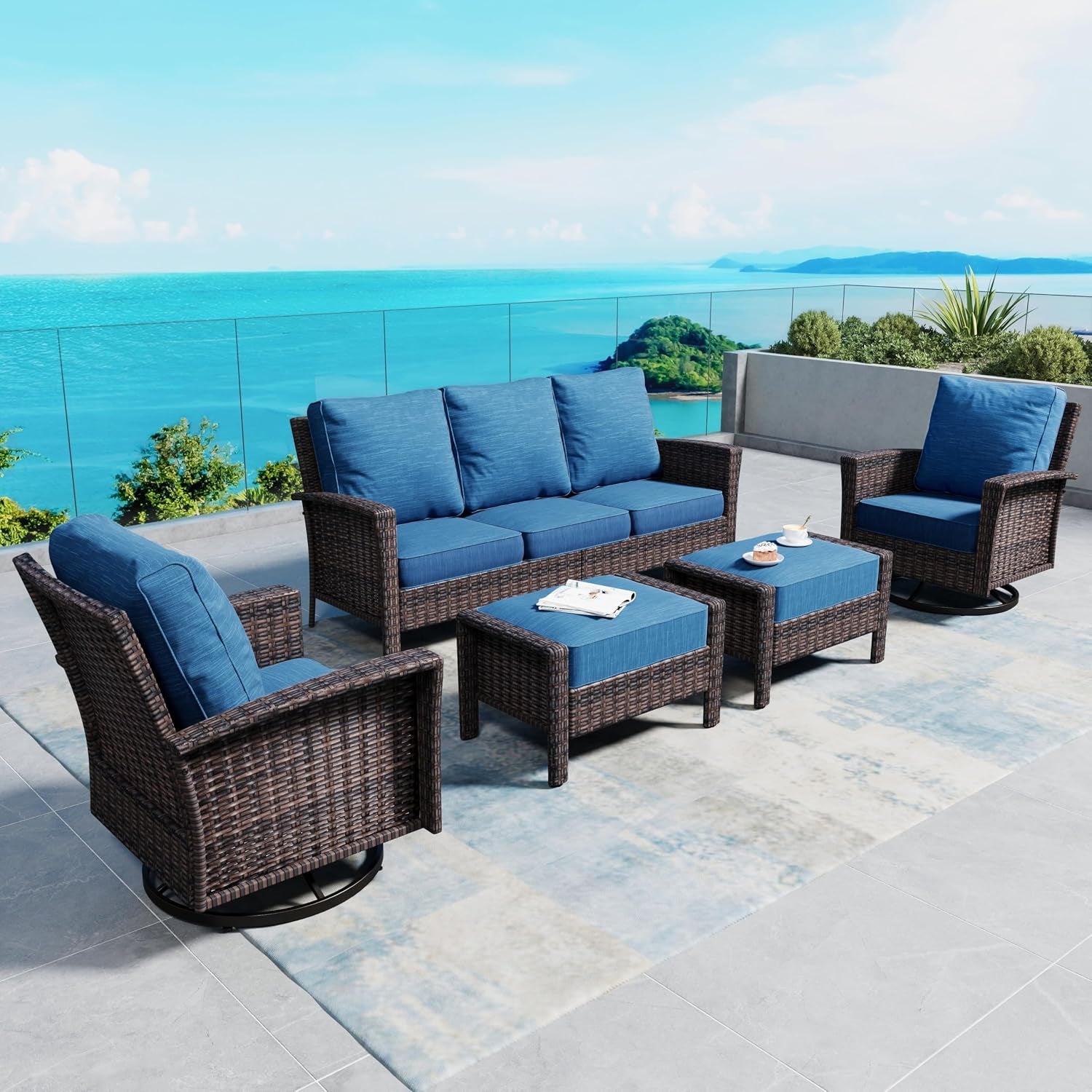Full patio seating set with a three-seat sofa, two chairs and two ottomans in blue cushions.
