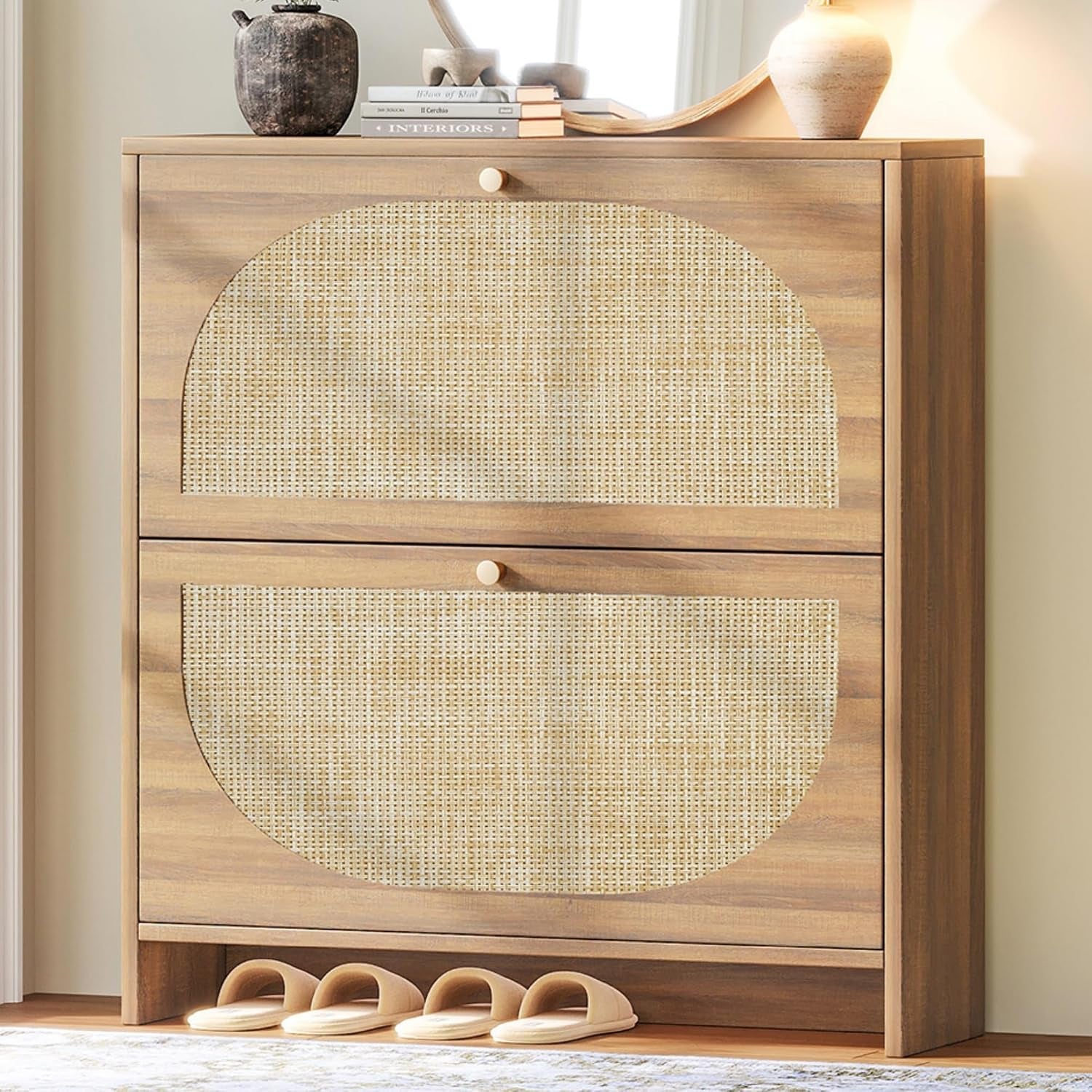 Close-up of two large rattan-front drawers topped with decorative vase, books and mirror