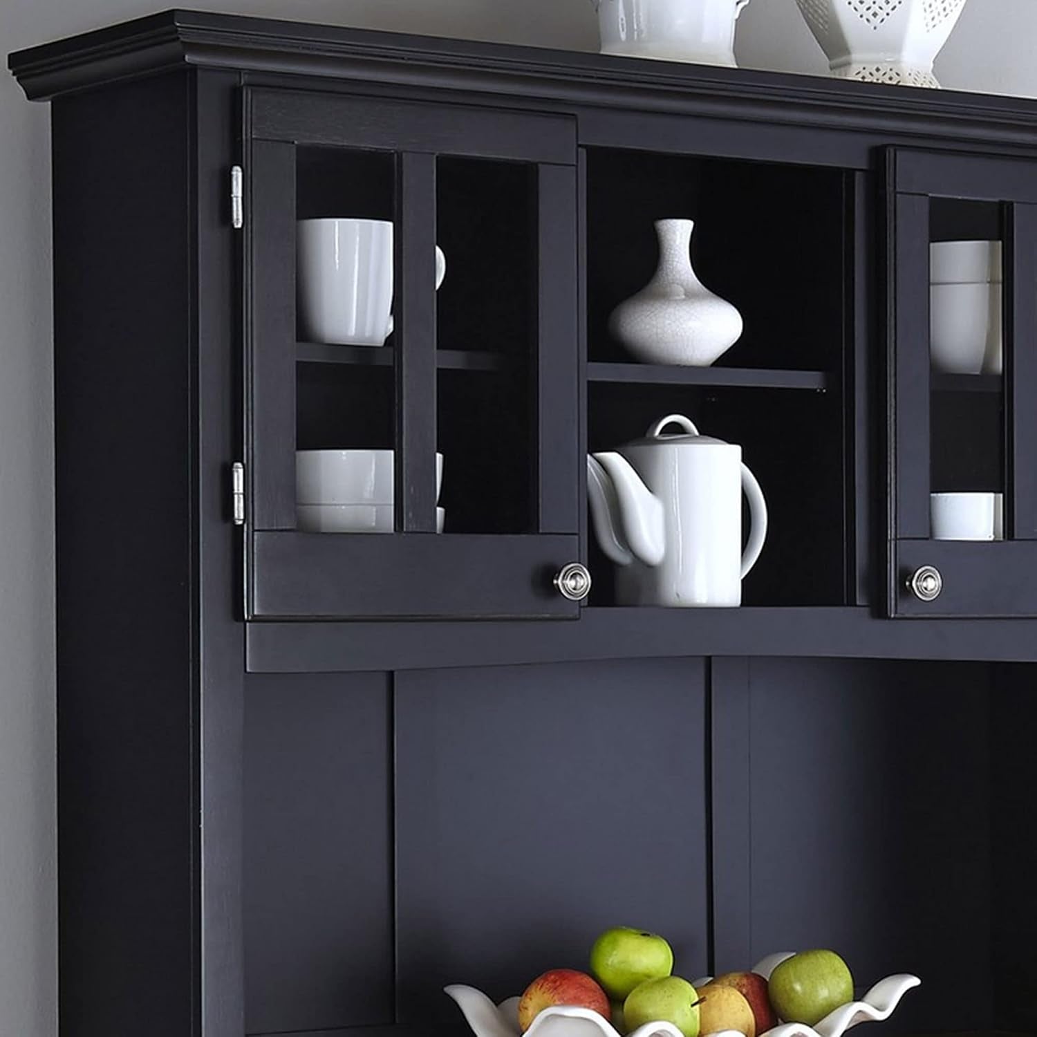 Close-up of hutch showing wood-framed glass doors and interior adjustable shelf with display items