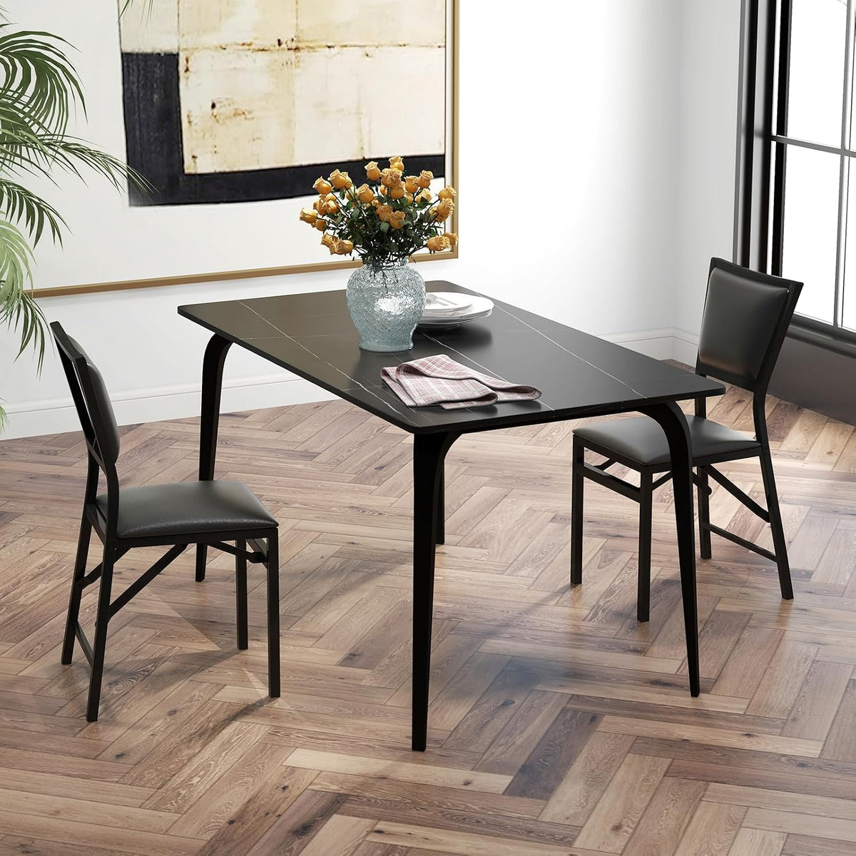 Two black folding dining chairs at a black dining table in a bright, minimalist dining room scene
