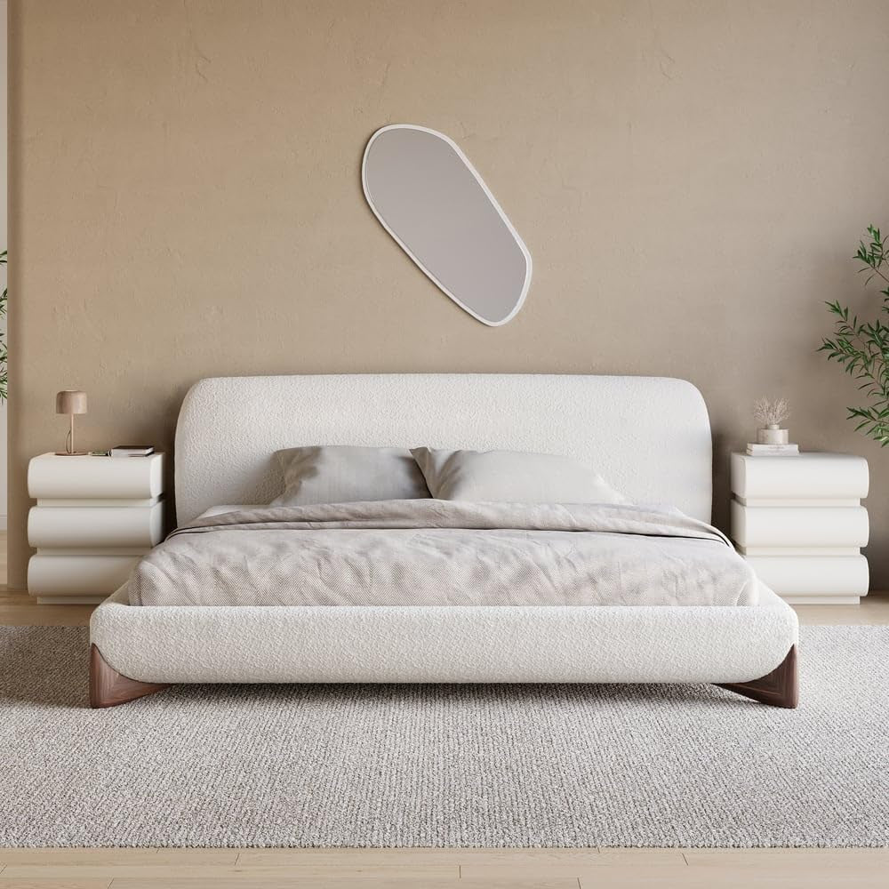 Low upholstered bouclé platform bed with rounded headboard and matching nightstands in neutral bedroom