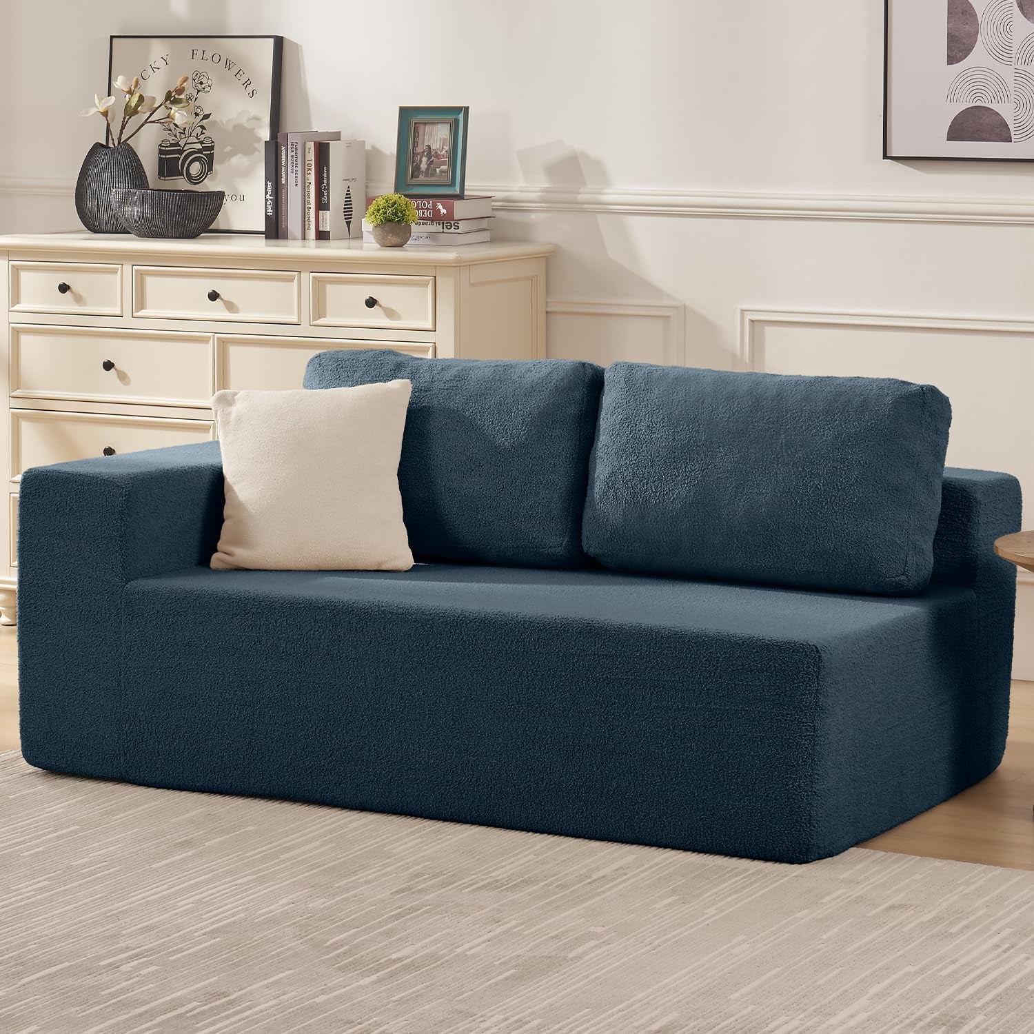 Deep teal two-seat modular sofa section with low arm, two back cushions and a light throw pillow.