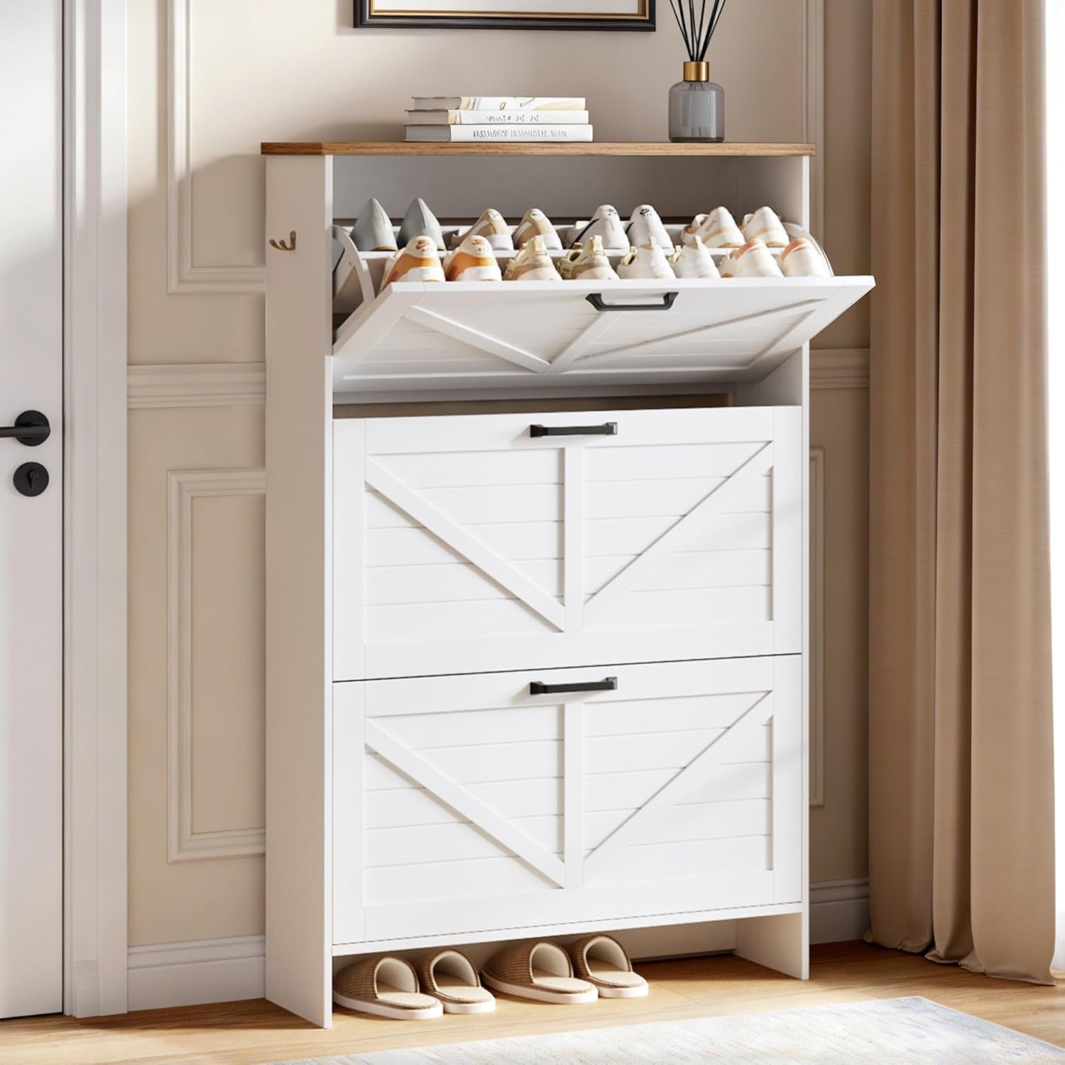 White shoe cabinet with wood top, showing the top flip drawer open with shoes inside.