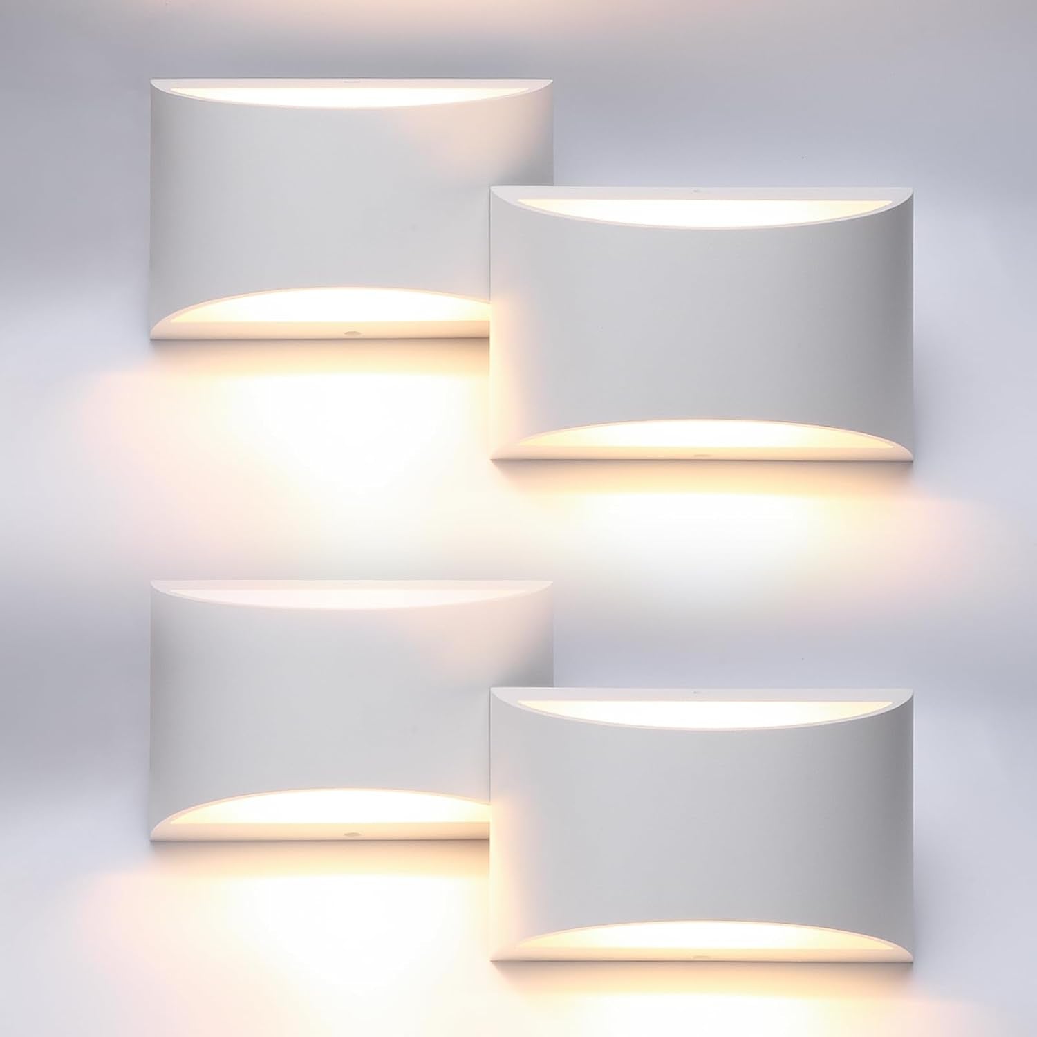 Four white rectangular wall sconces arranged in two rows, each emitting warm up-and-down light.