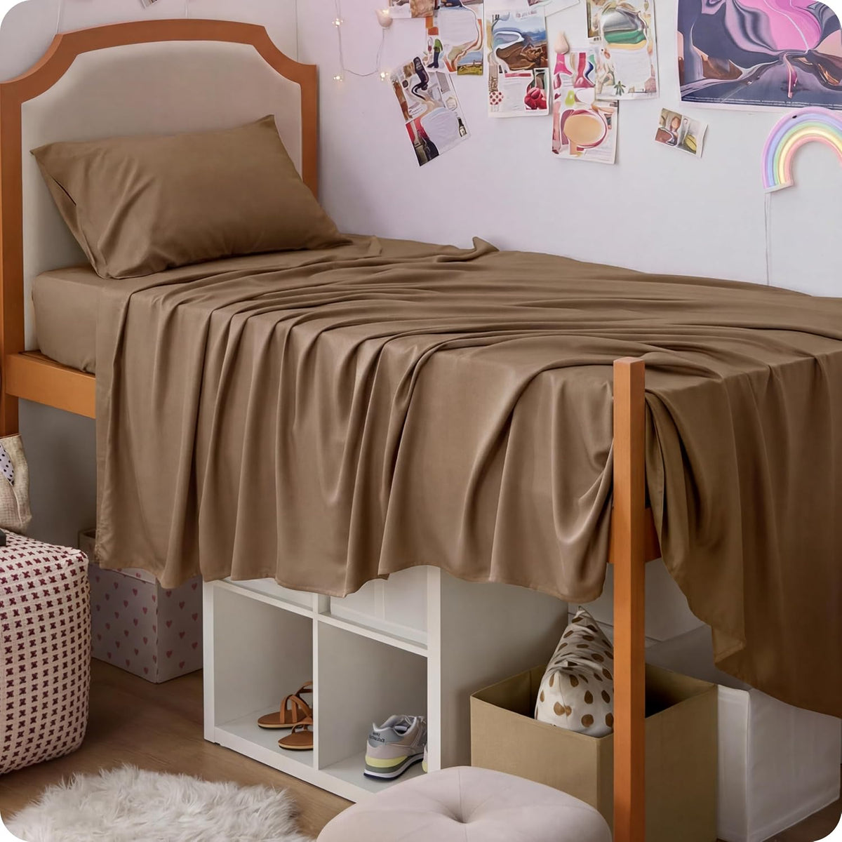 Single loft-style bed with brown sheets draped over the sides and storage below