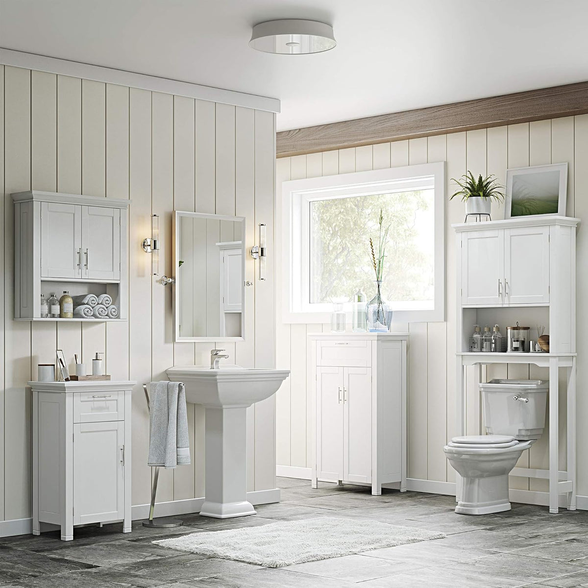 Bathroom scene showing the white wall cabinet mounted above a pedestal sink next to a mirror and wall sconces