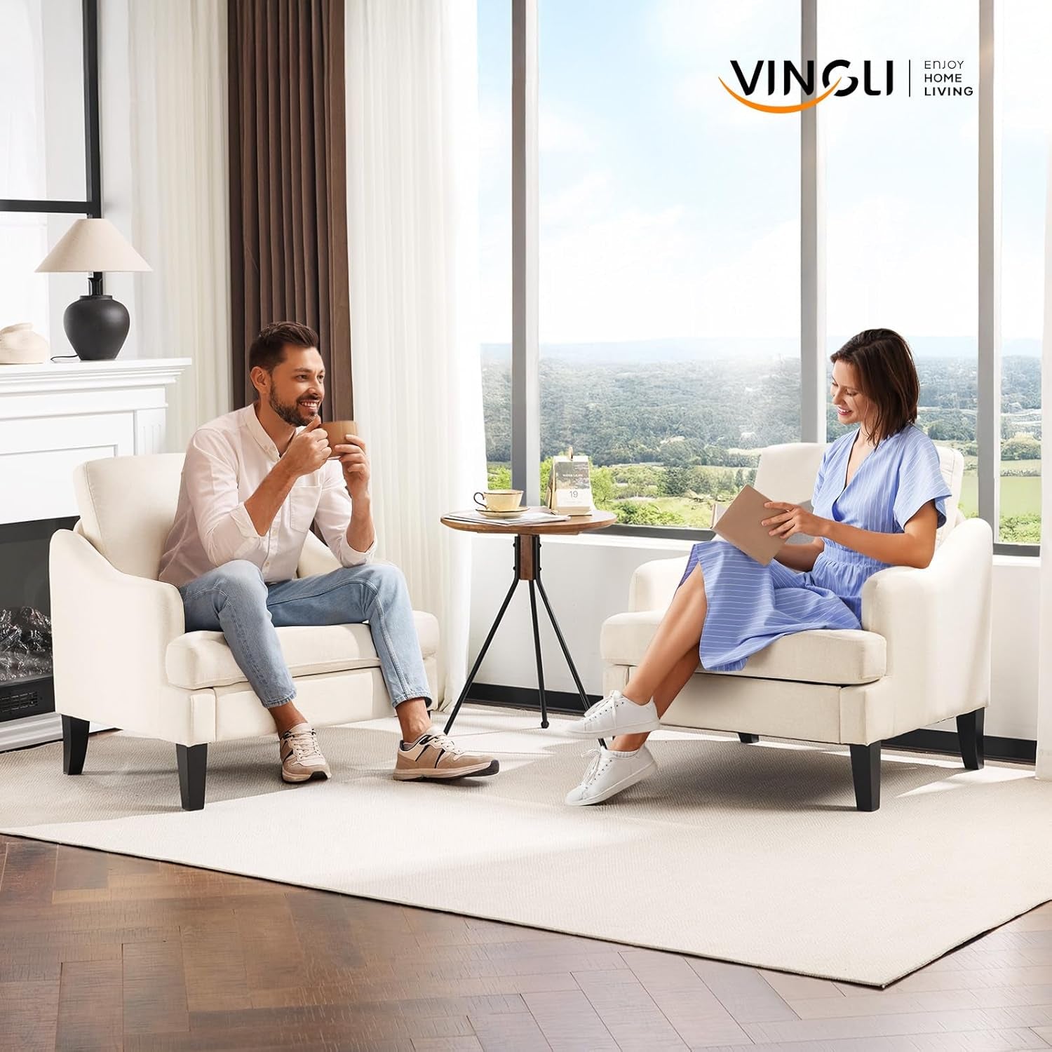 Two beige armchairs in a bright living room with a man and woman seated, a small round table between them and