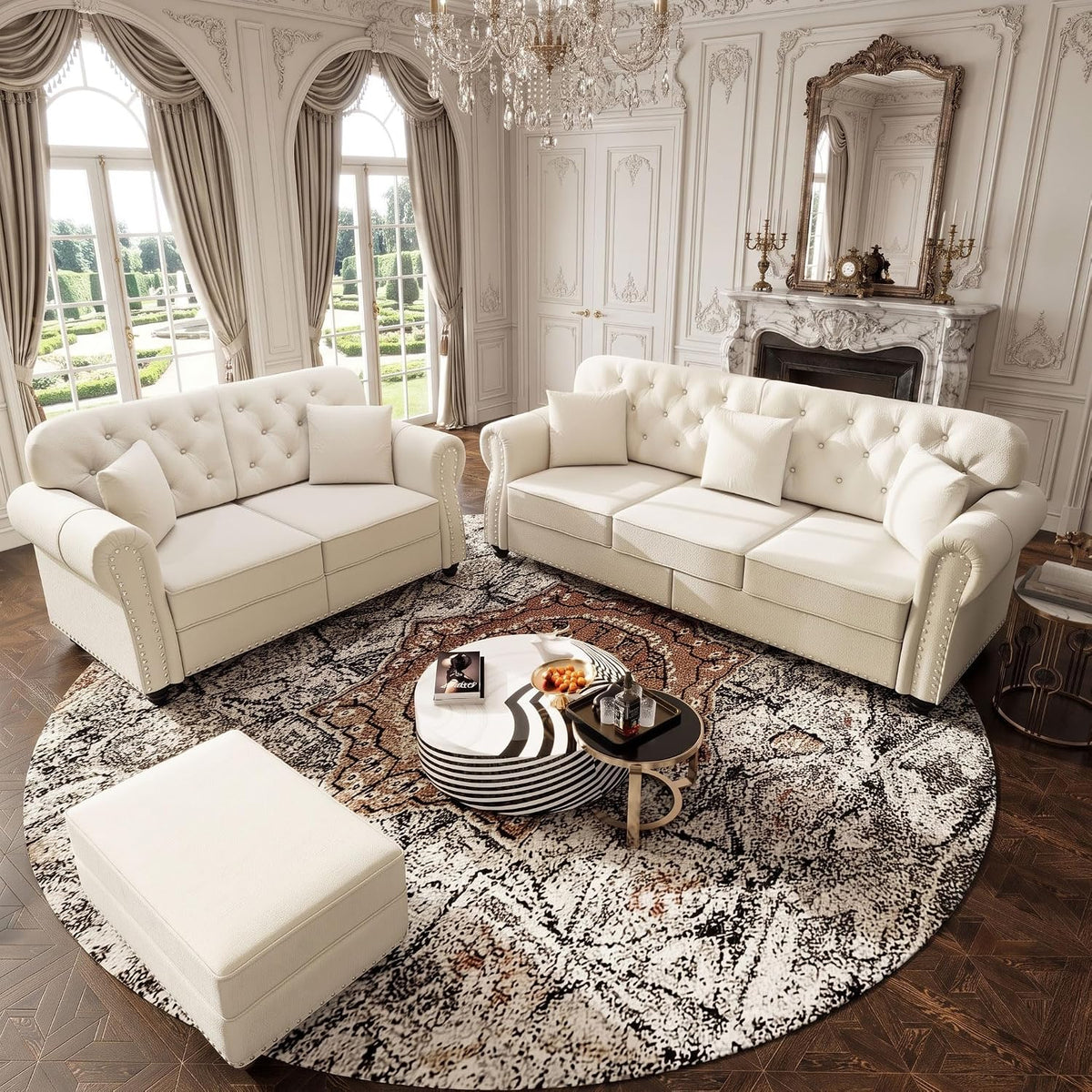 Room-staged view of beige velvet Chesterfield sofa, loveseat and ottoman arranged on a round patterned rug