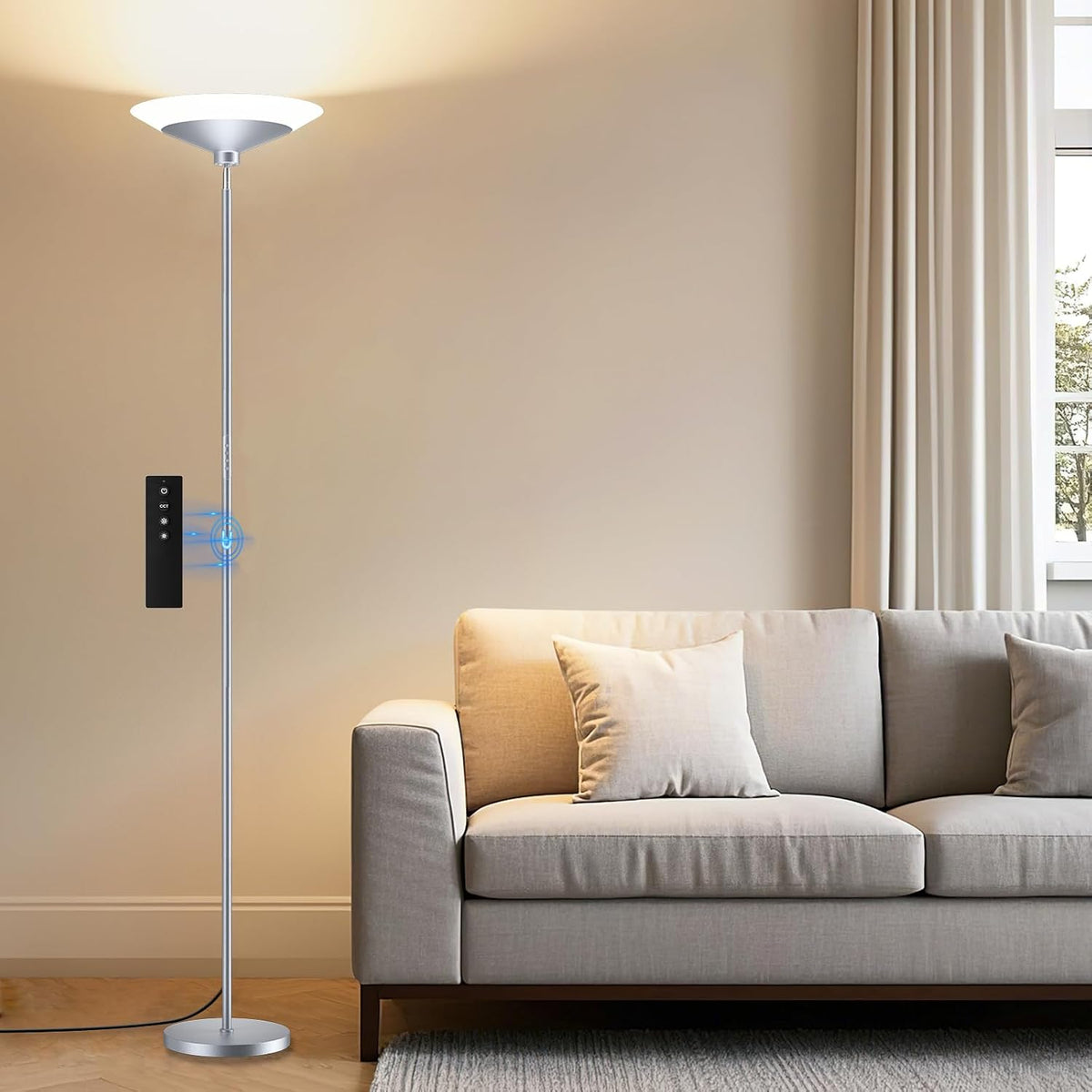 Matte silver torchiere lamp standing next to a light-gray sofa, illuminating the upper wall.