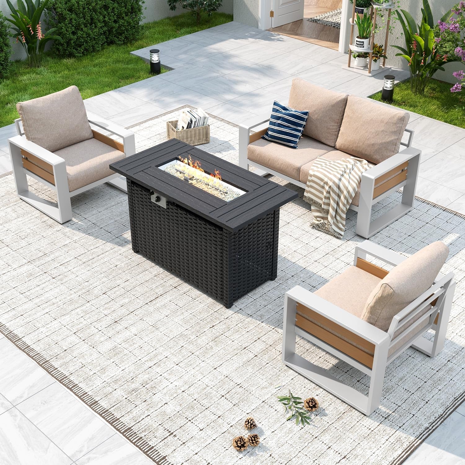 Overhead patio view of beige-cushioned seating: two armchairs and a loveseat arranged around a black fire-pit table on a