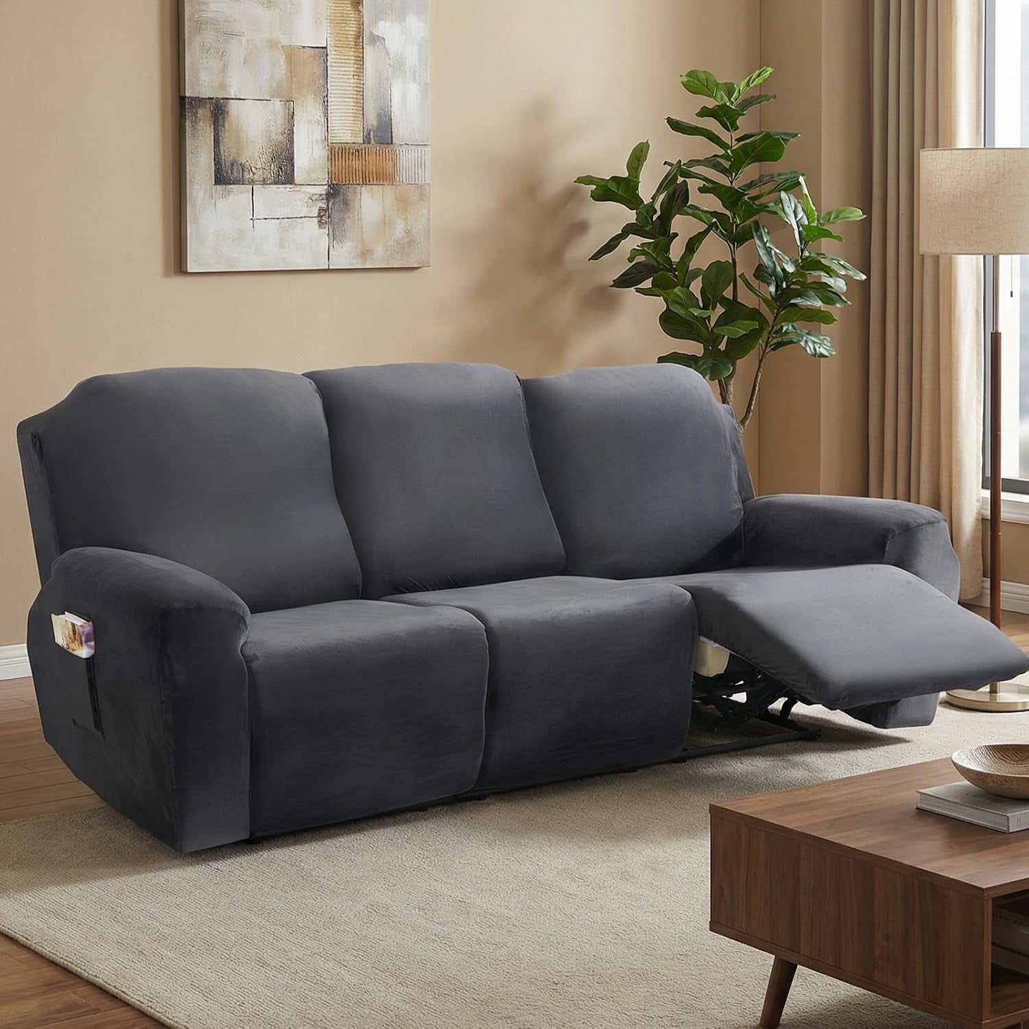 Dark grey velvet recliner sofa cover installed in a living room with the right-seat footrest extended and side pocket visible