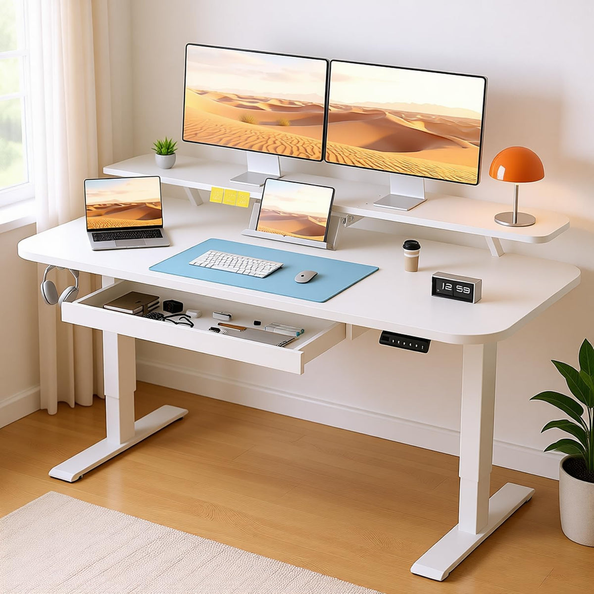 Angled right room view of a white standing desk with open drawer, dual monitors on a raised shelf and headphones on a hook.