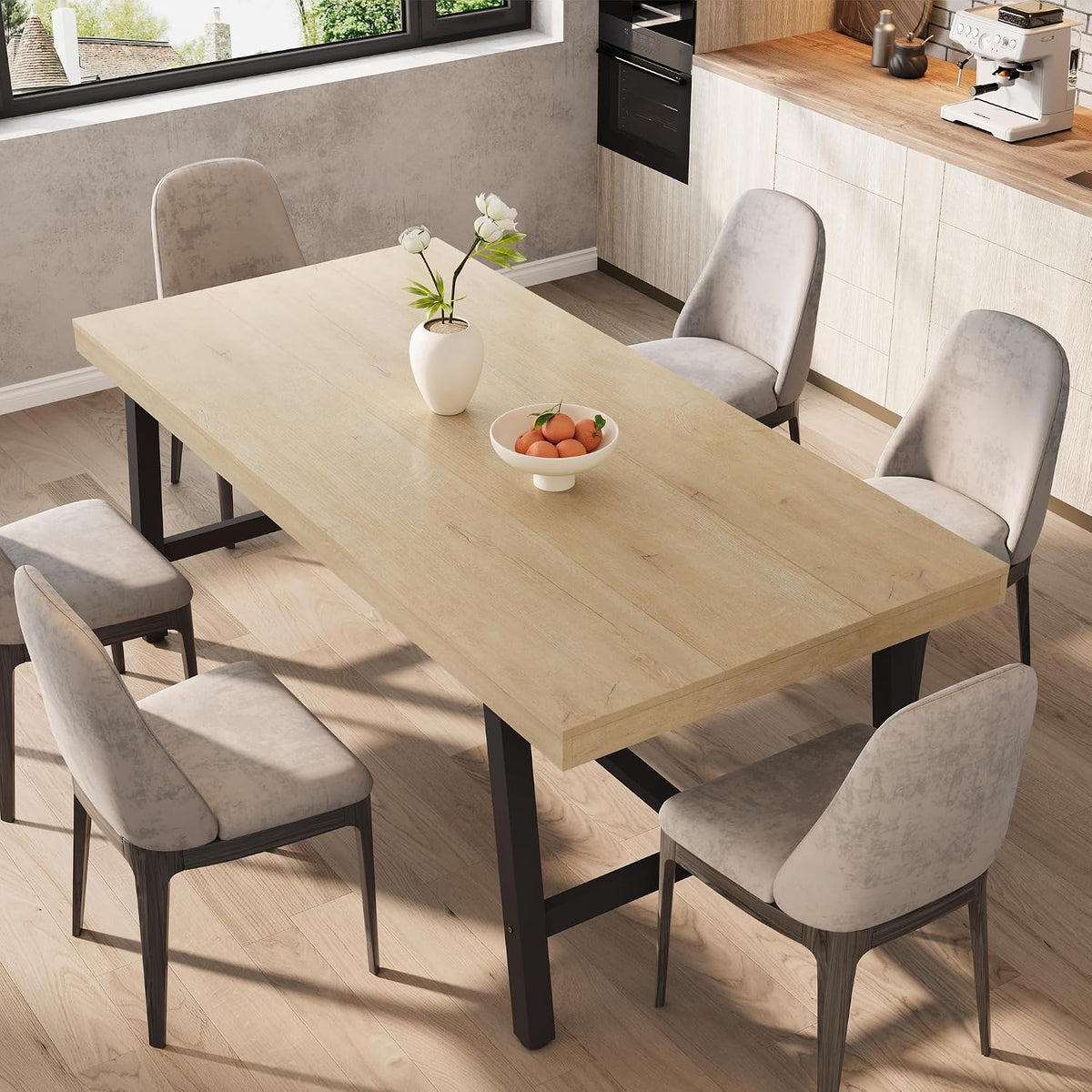 Overhead view of light wood extendable table with fruit bowl and vase, framed by upholstered dining chairs.