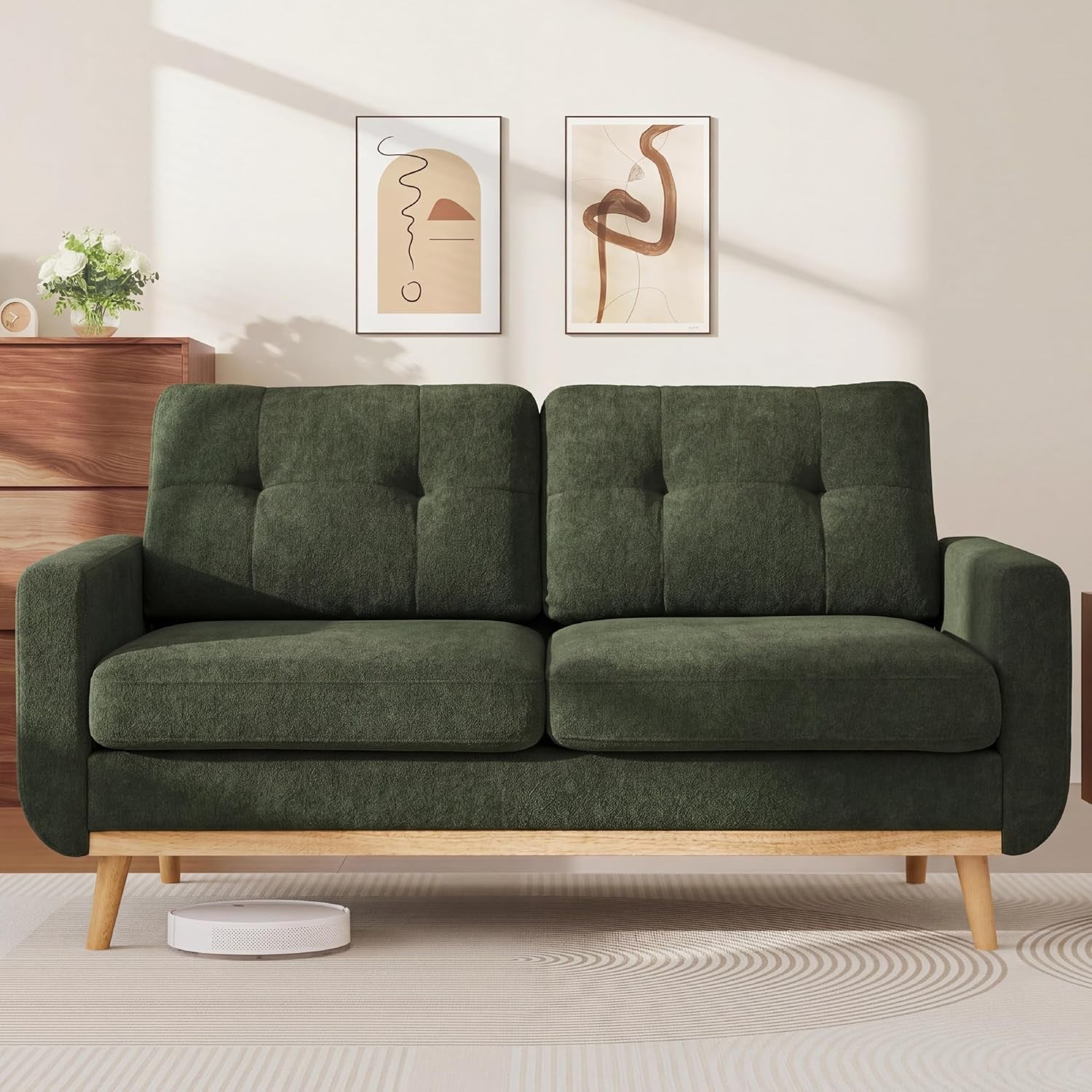 Front-facing view of a green tufted loveseat on wood legs in a minimal room.