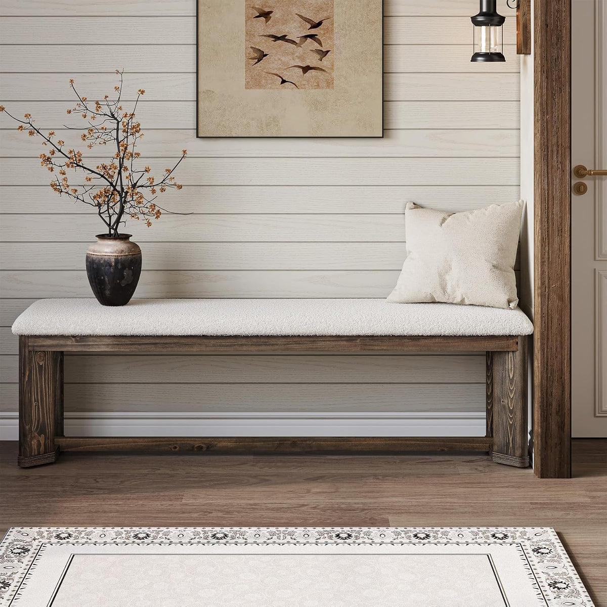 Long bench with cream-colored faux fur seat and distressed wood base against a shiplap wall with a vase