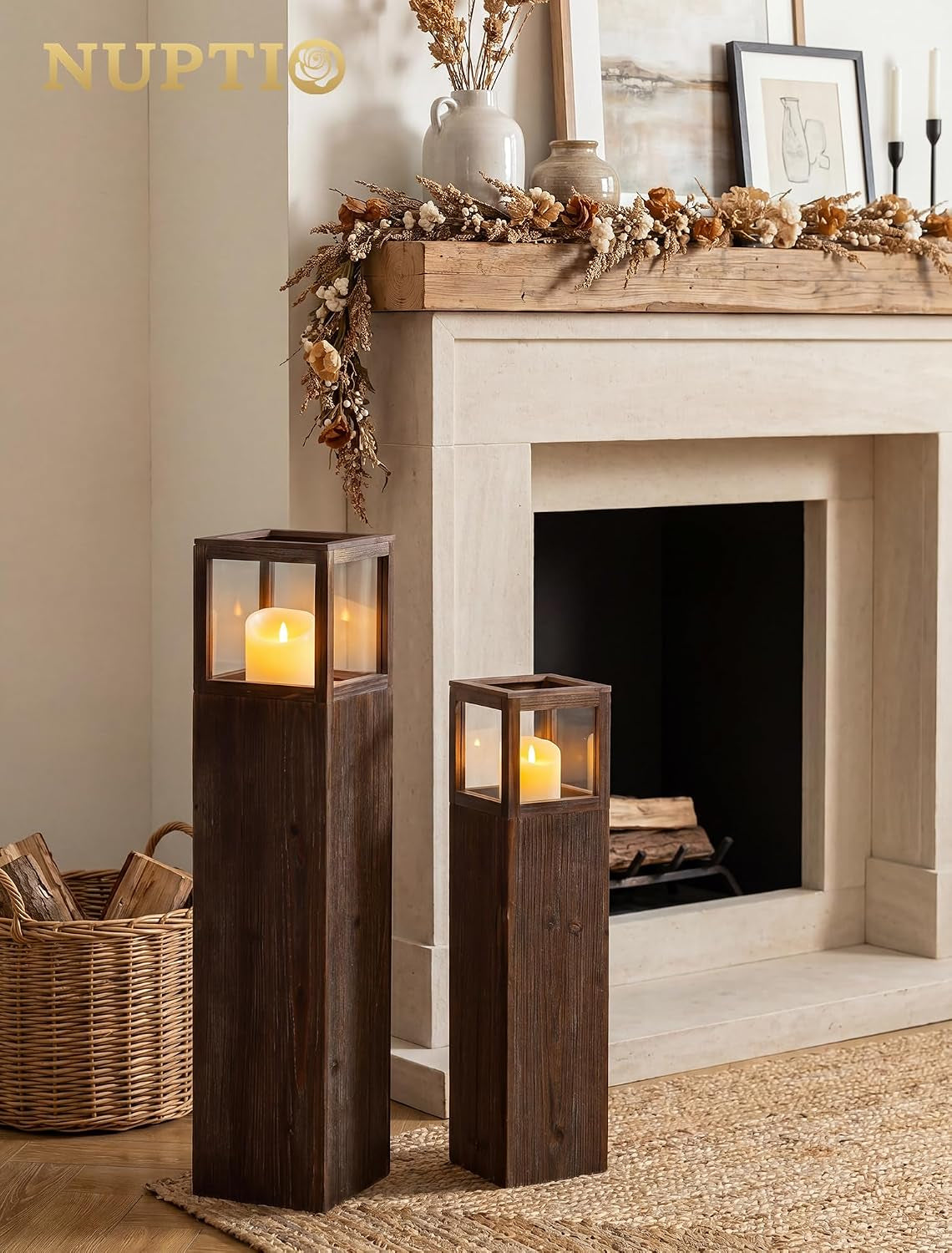 Pair of tall distressed wood lanterns styled on a living room floor in front of a fireplace
