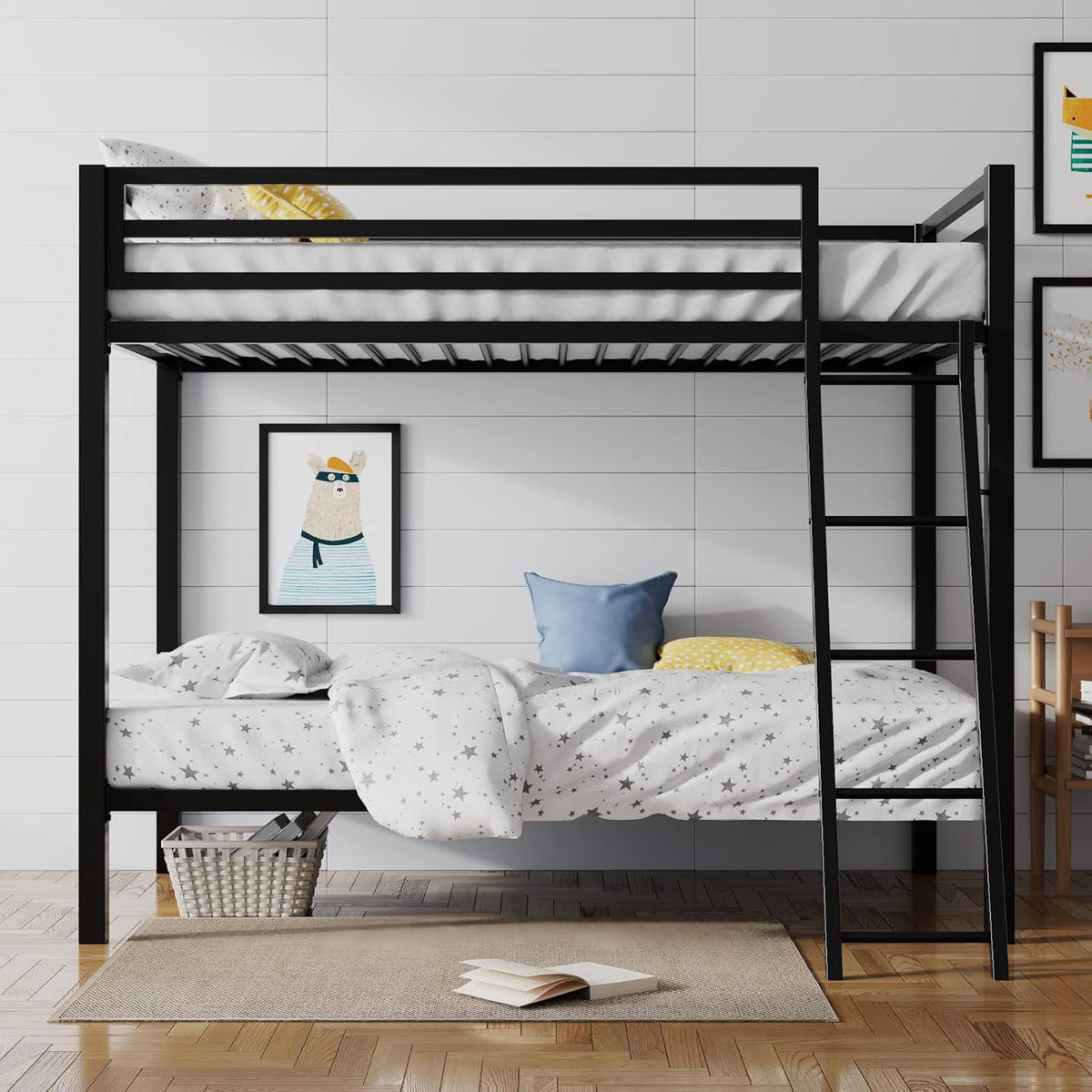 Front view of a black metal bunk bed with star-print bedding, decorative pillows, and ladder leaning on the right side.