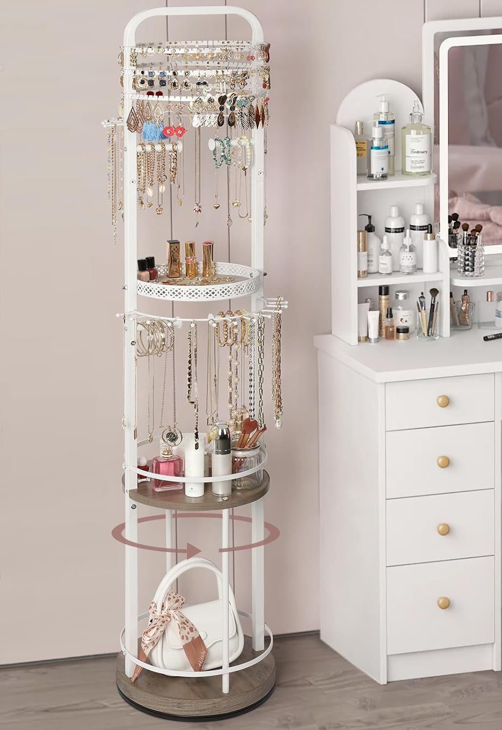 White freestanding rotating jewelry organizer holding necklaces, earrings and cosmetics next to a white vanity.