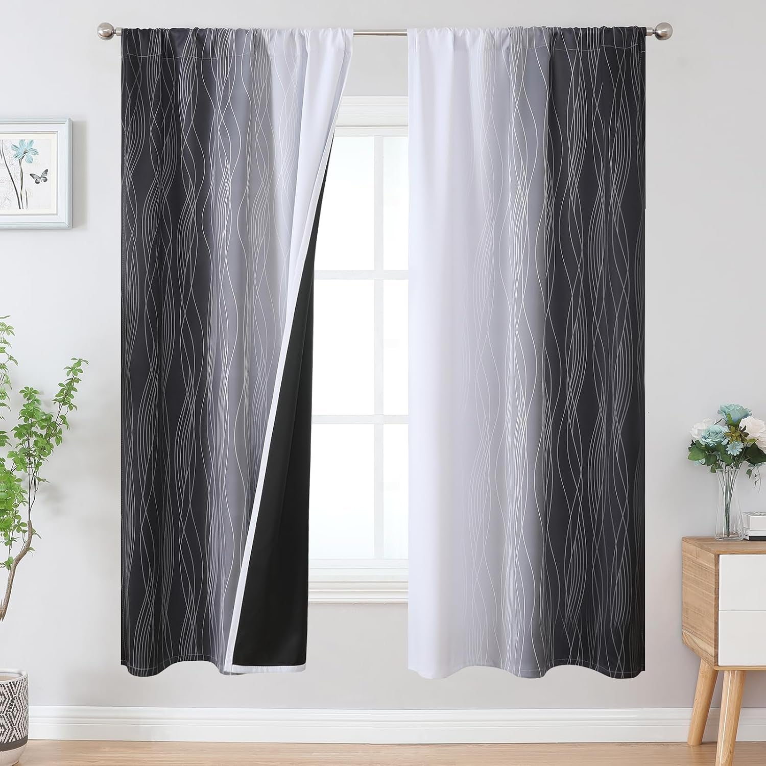 Window with dark grey-to-white ombre patterned curtains, one panel opened to reveal black backing and white inner panel.