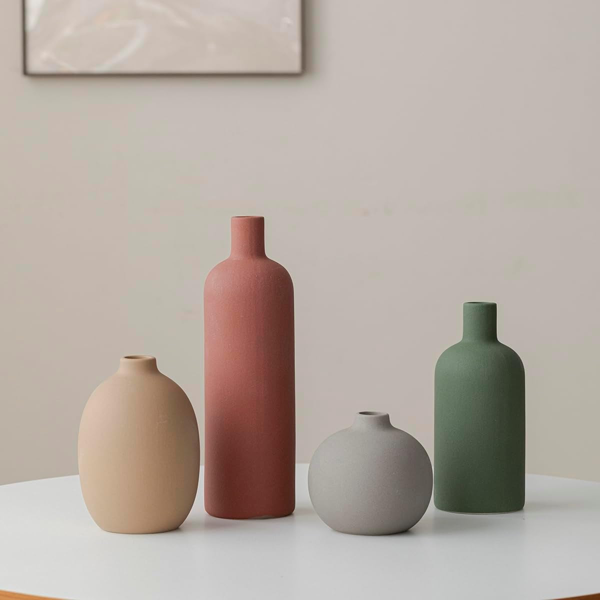 Straight-on grouping of the four vases arranged in height order on a round white table