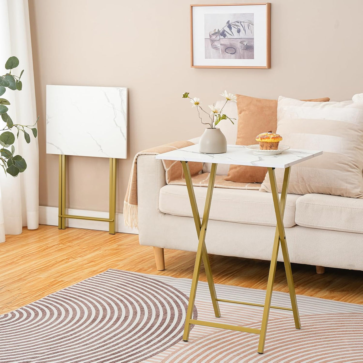 One folded marble-pattern tray table standing against a wall next to a sofa