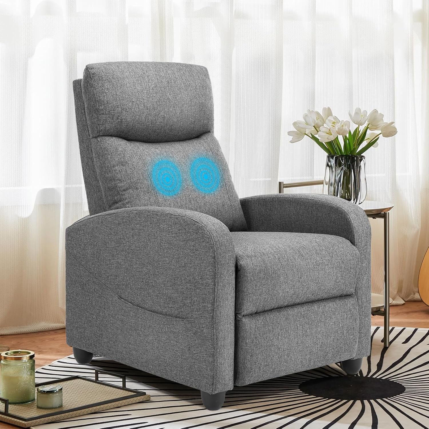 Grey fabric recliner in a sunlit living room with two blue glowing massage target graphics on the backrest.