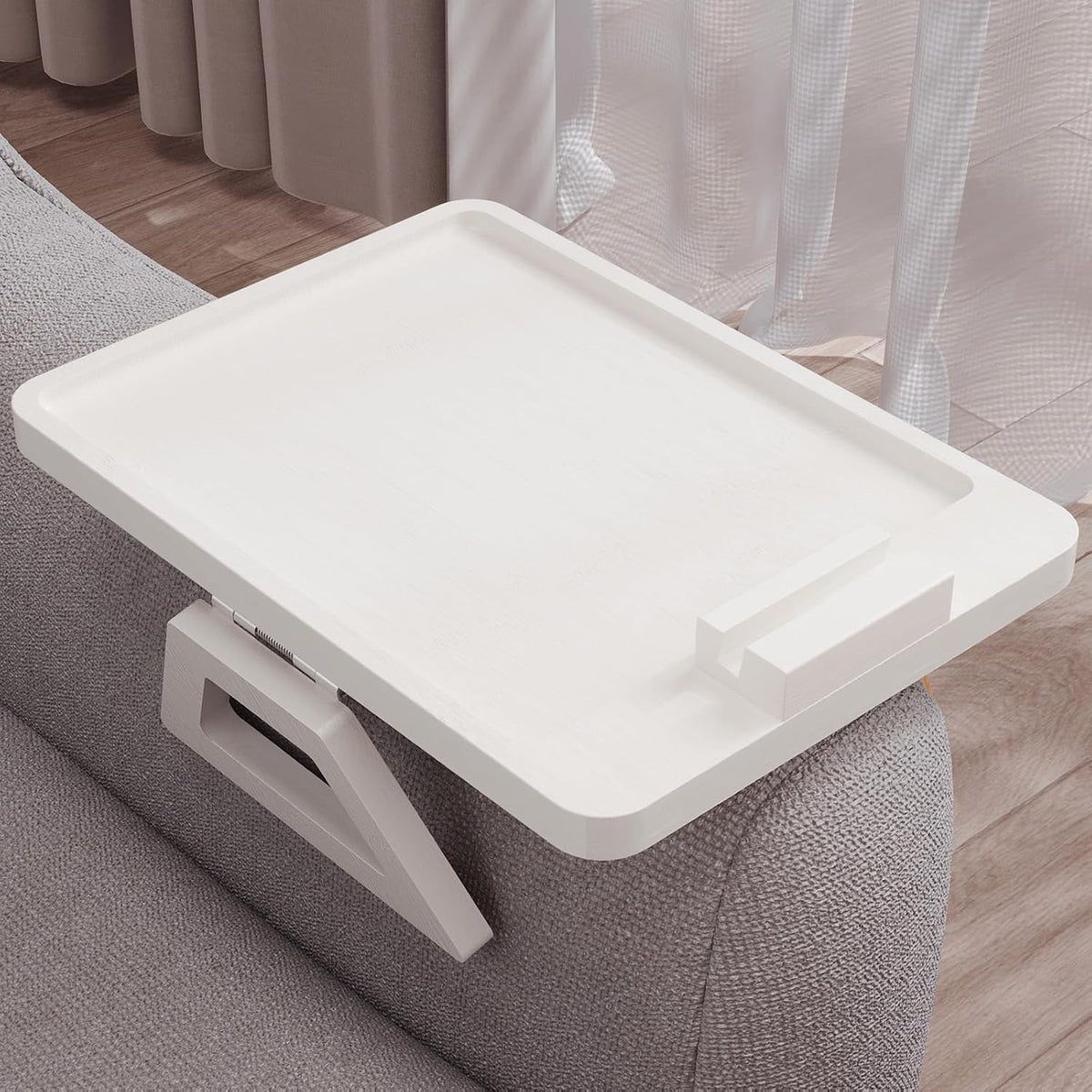 White tray with detachable phone holder block placed at the front edge over a fabric armrest