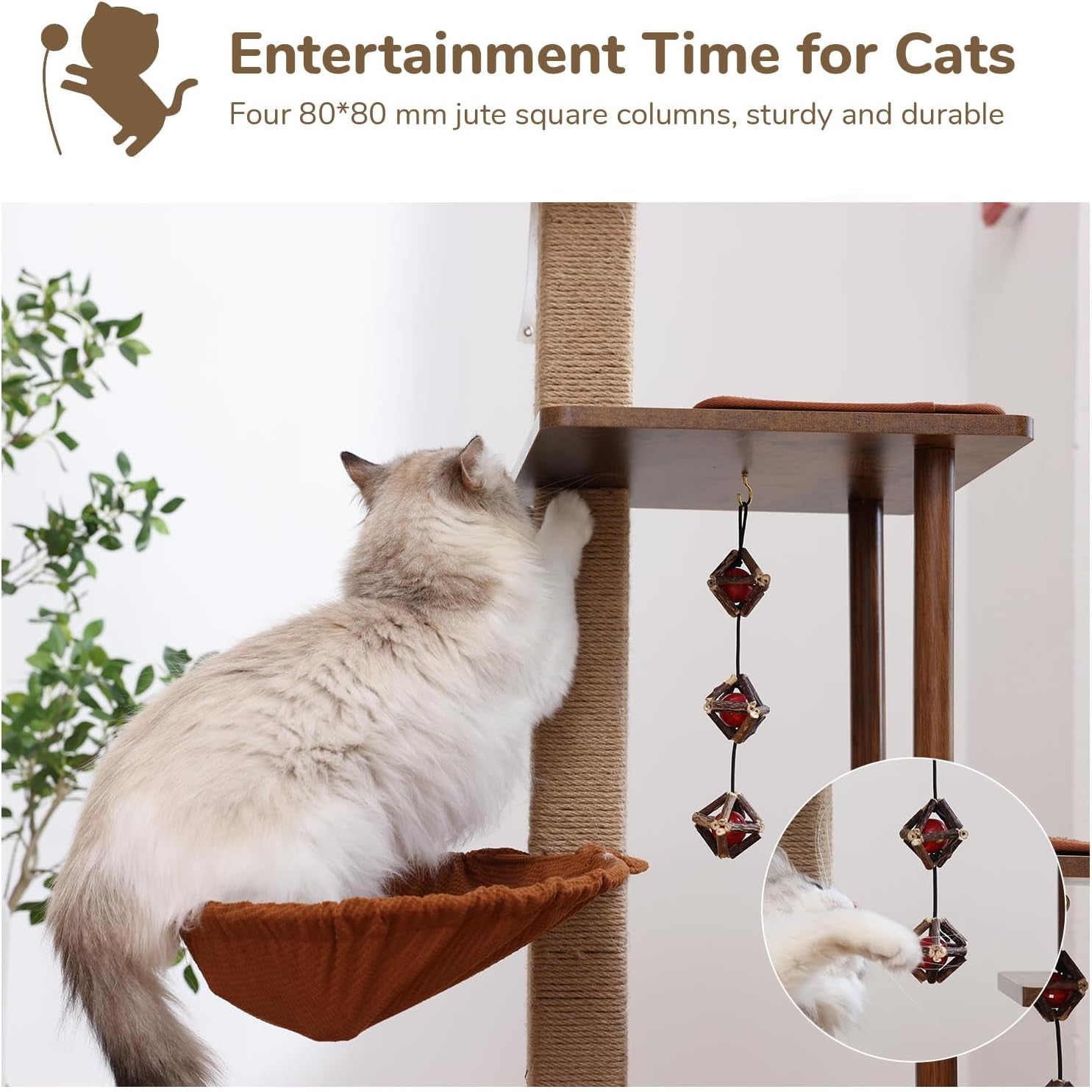 Fluffy white-and-gray cat standing in a hammock, reaching up to a tall jute-wrapped scratching post with a dangling bead toy.
