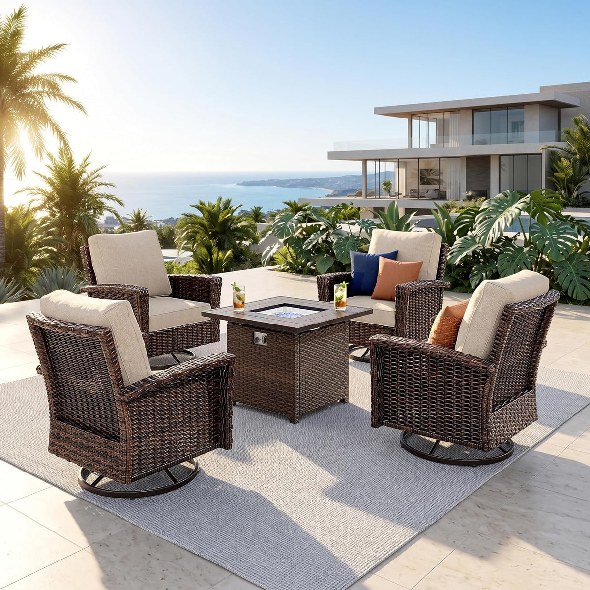Four swivel wicker chairs arranged around a square fire table on a sunny terrace with ocean view.
