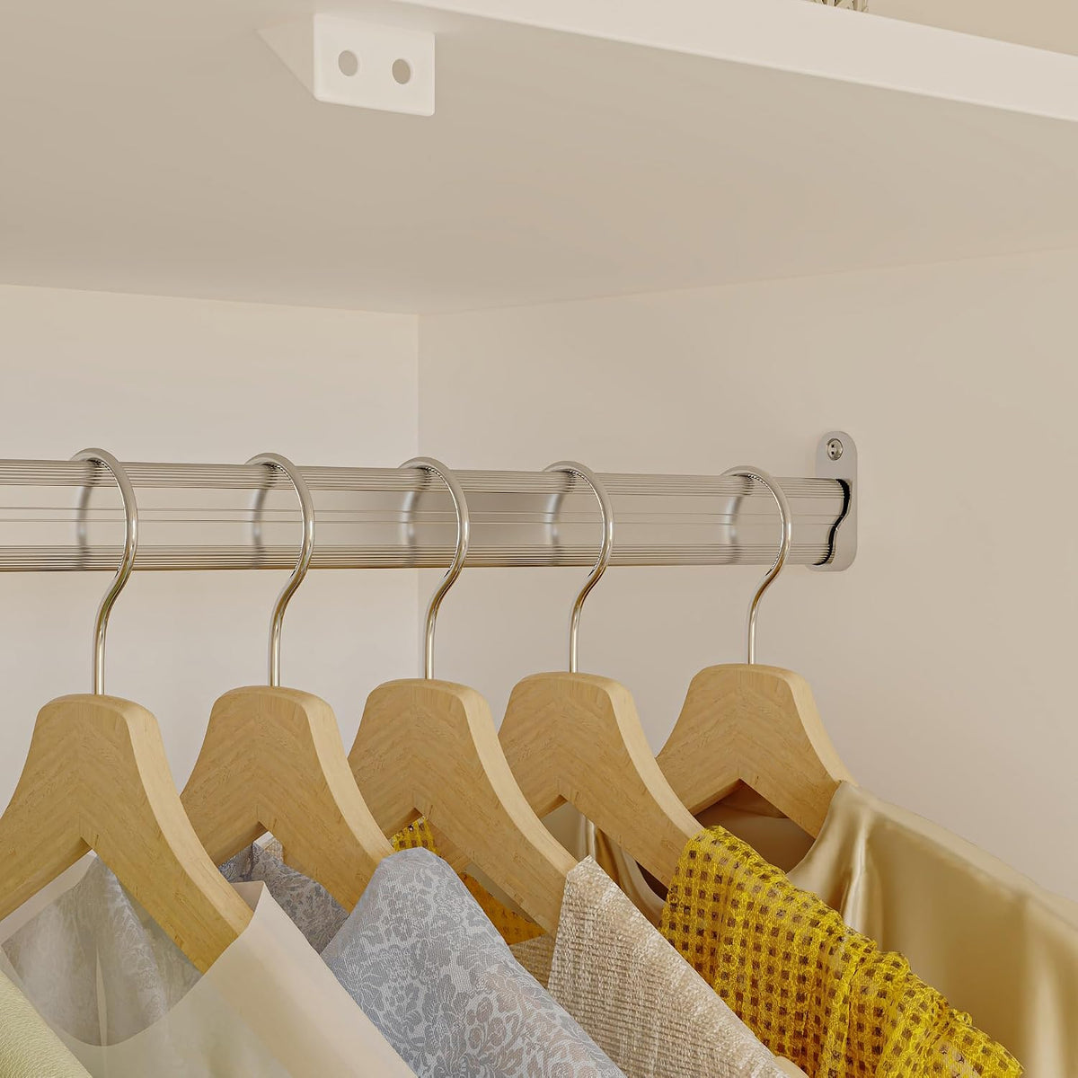 Close-up of the metal hanging rod with wooden hangers and garments inside the wardrobe interior