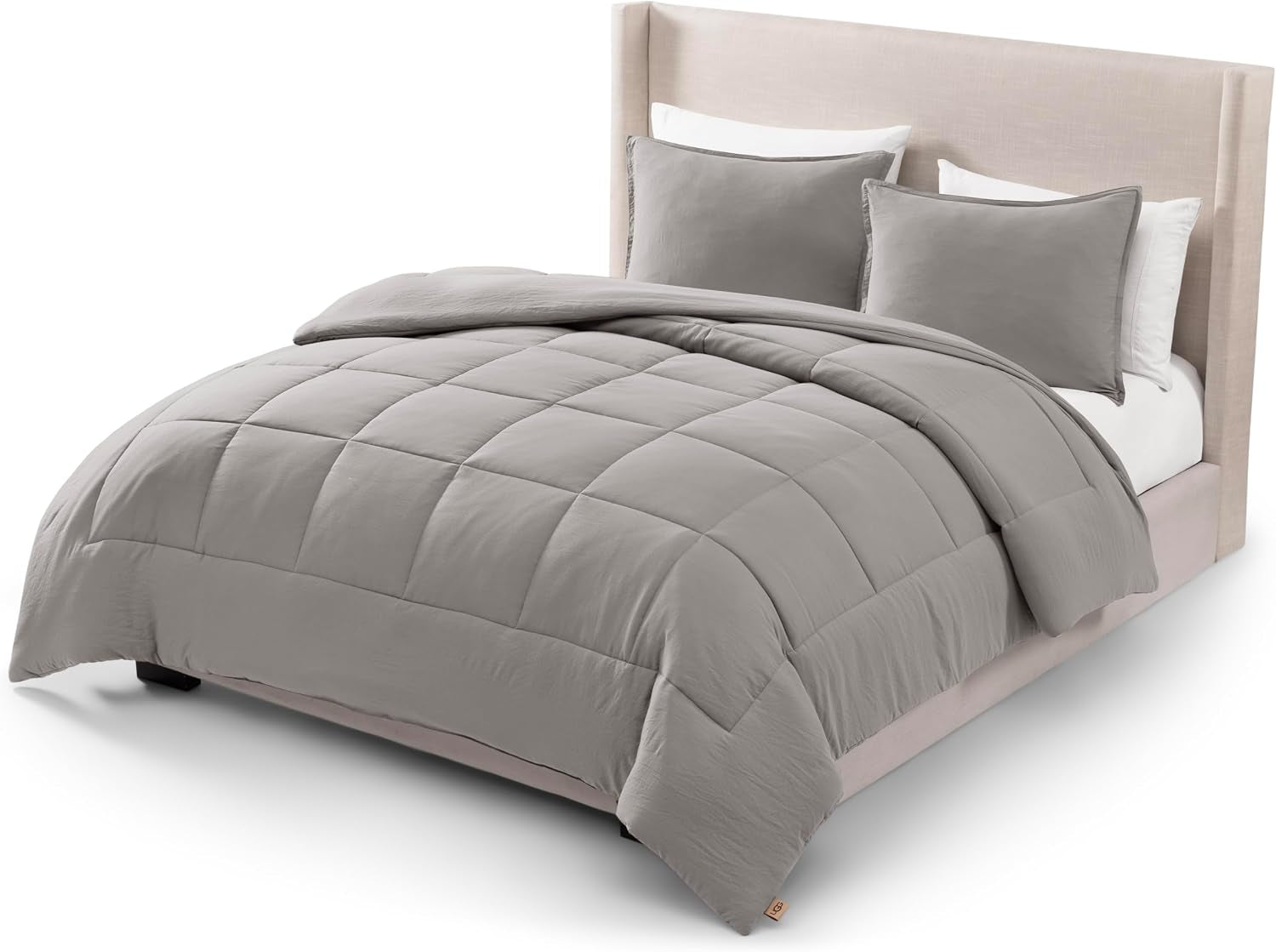 Light grey comforter draped on bed with two matching shams, isolated on a white background, angled front view