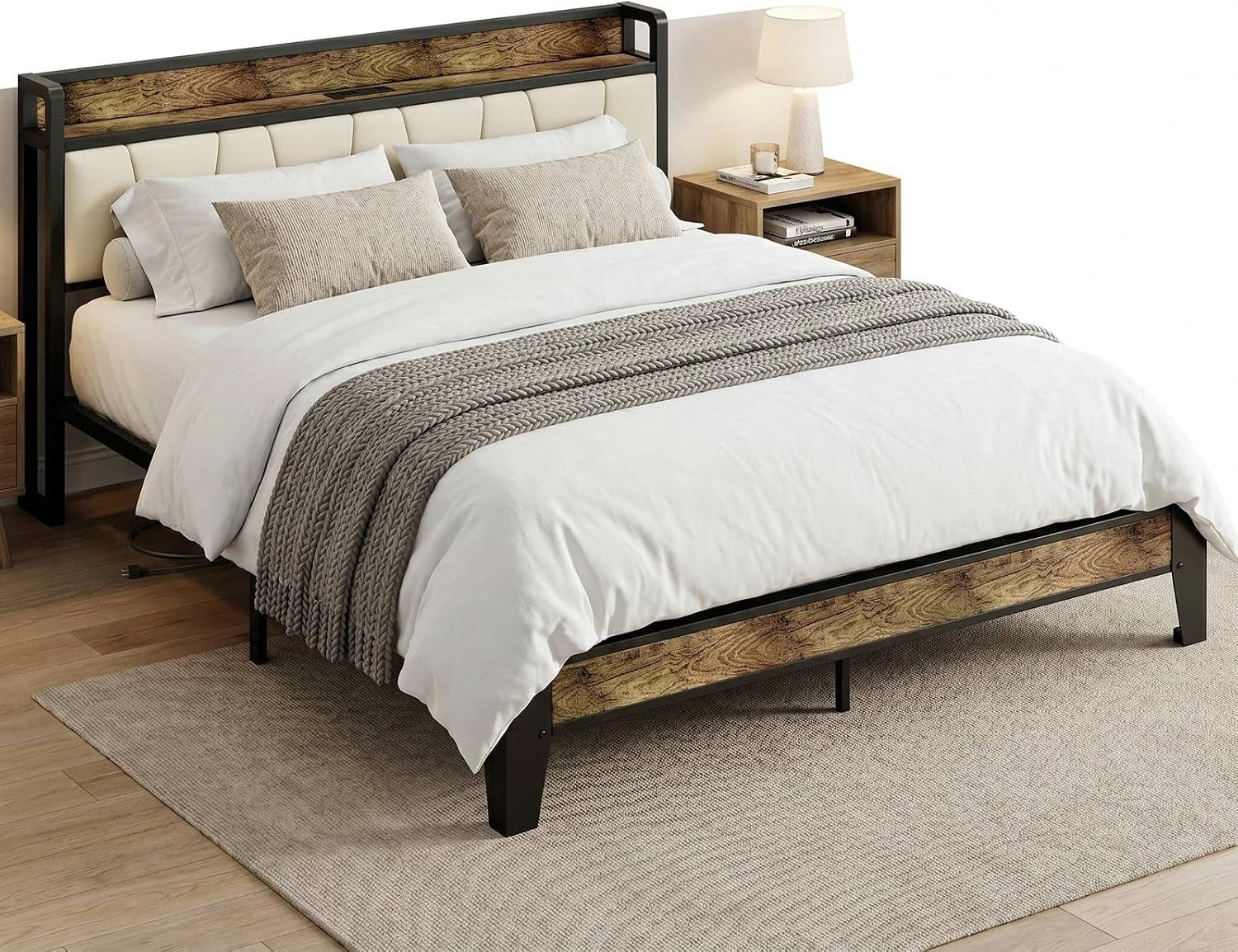 Angled view of a bed with wood-look panels and a black metal frame, a chunky knit throw over white bedding.