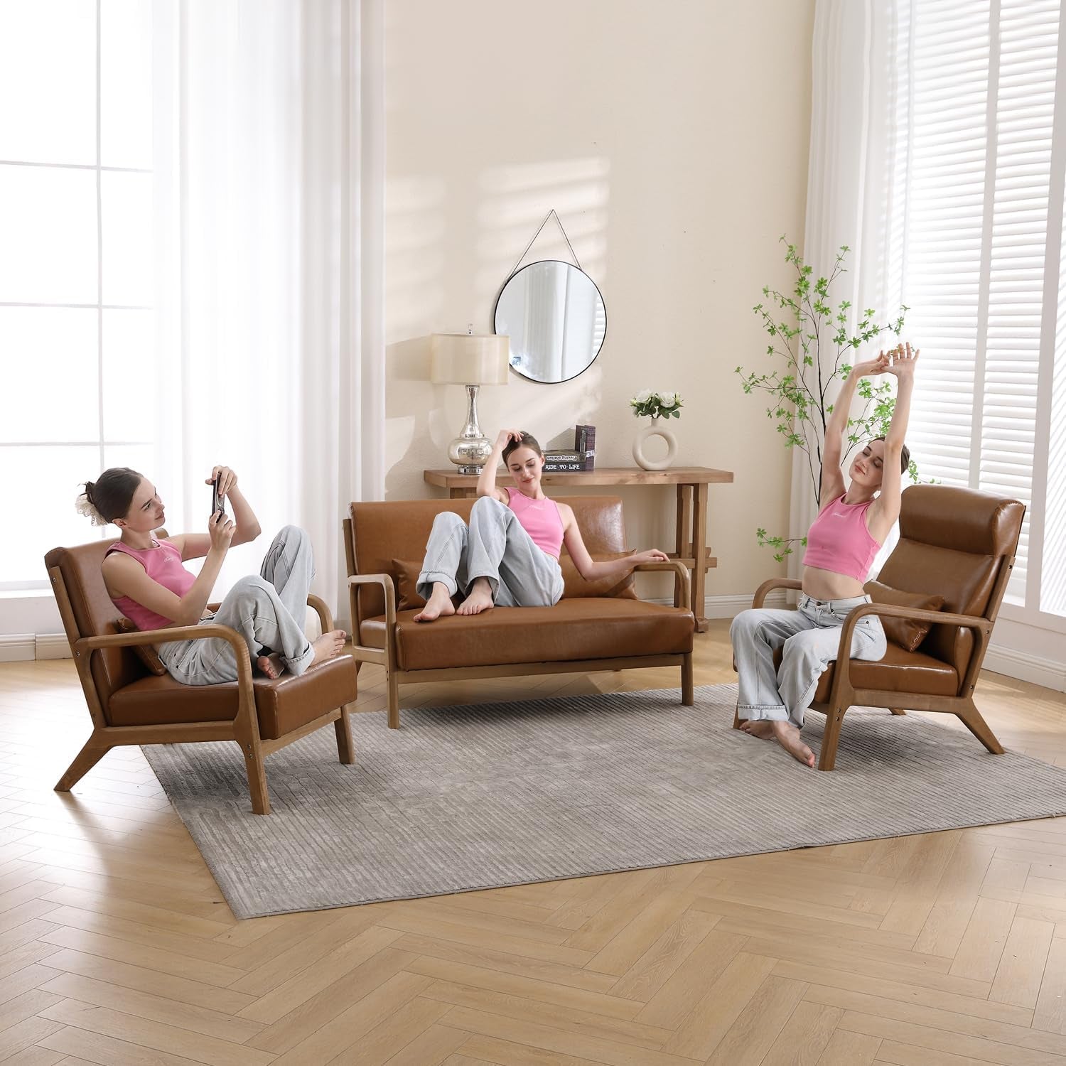 Living room scene with three brown leather mid-century chairs and a matching loveseat on a gray rug.