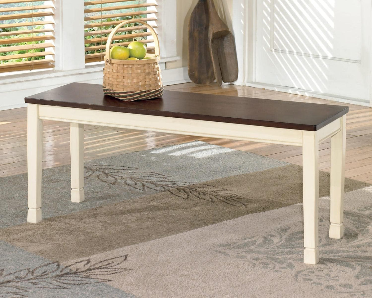 Two-tone backless bench with brown top shown on a rug in a bright entryway setting with window light