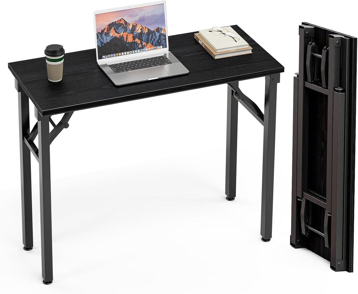 Black wood-finish desk shown assembled with an open laptop on top and the folded tabletop standing upright at the right.