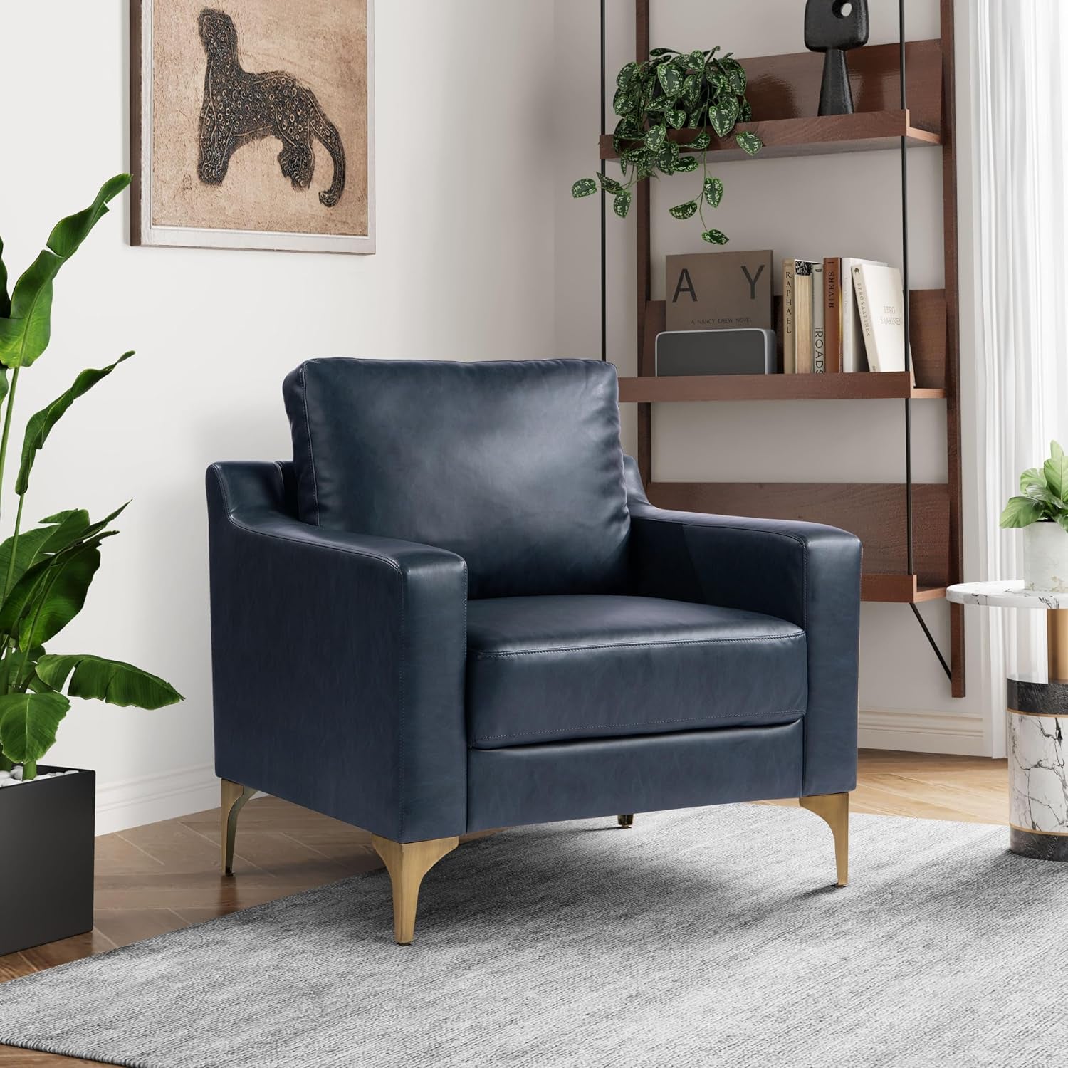Navy faux-leather armchair with angled gold legs shown in a styled corner.